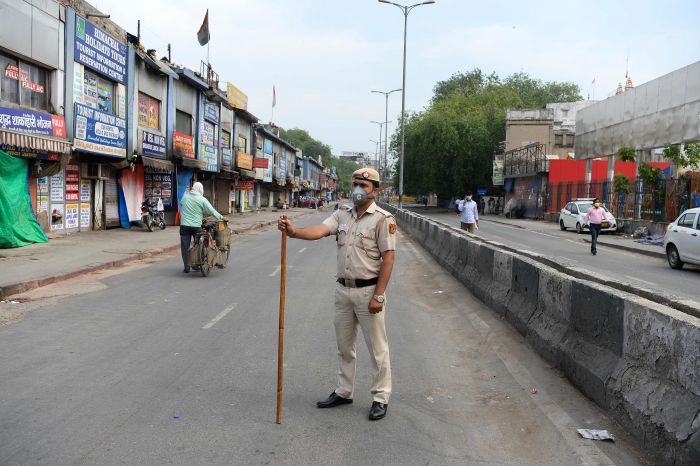 Seorang polisi berjaga di luar stasiun kereta api yang mulai melayani penumpang