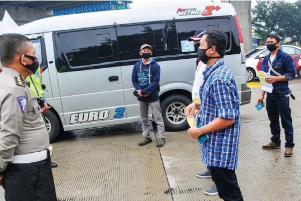 Polisi menjelaskan aturan larangan mudik kepada tenaga kerja Indonesia yang baru tiba dari Portugal di Tol Jakarta-Cikampek, kemarin.