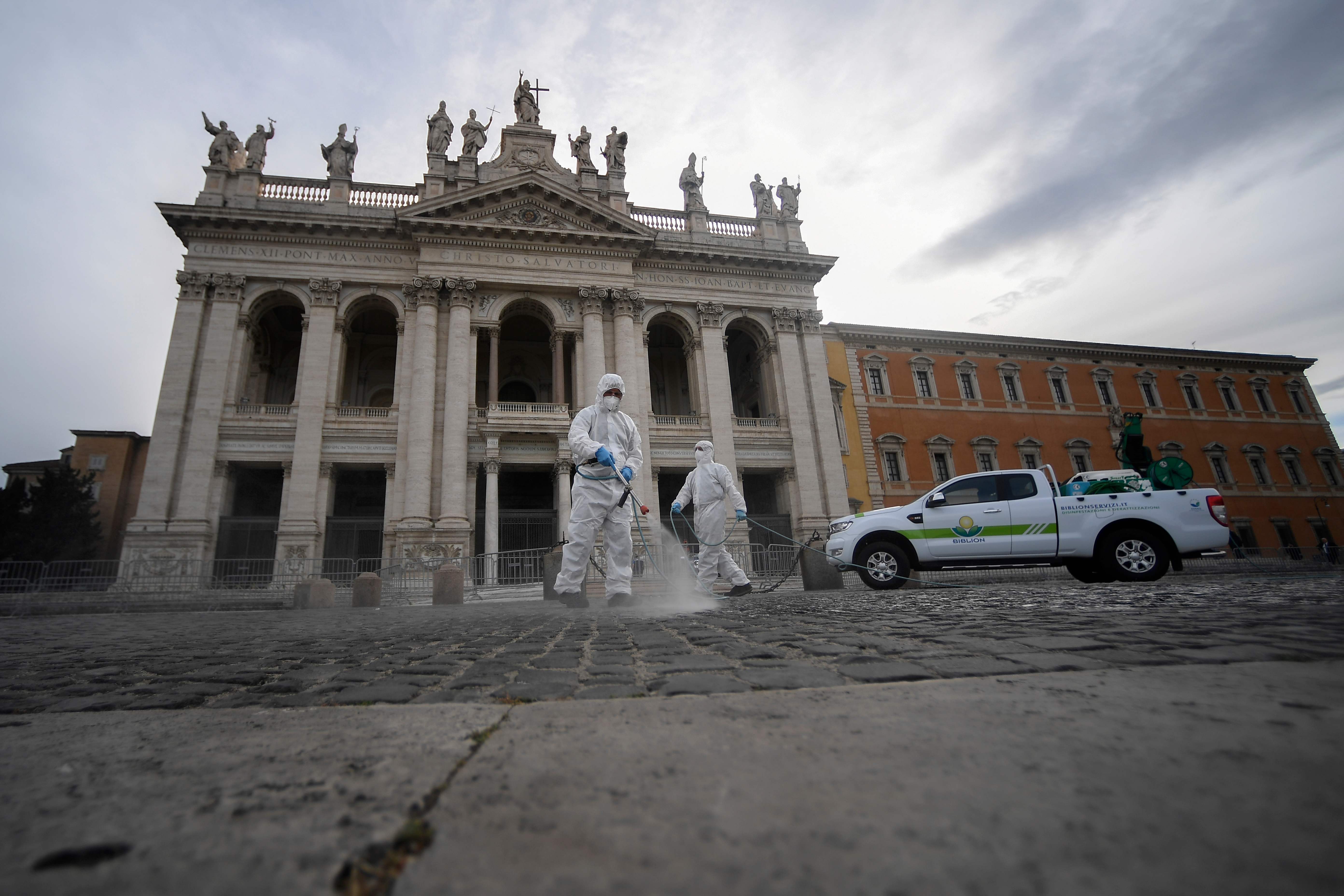 Petugas menyemprotkan disinfekrtan ke Basilika San Giovani in Laterano, Roma , Italia