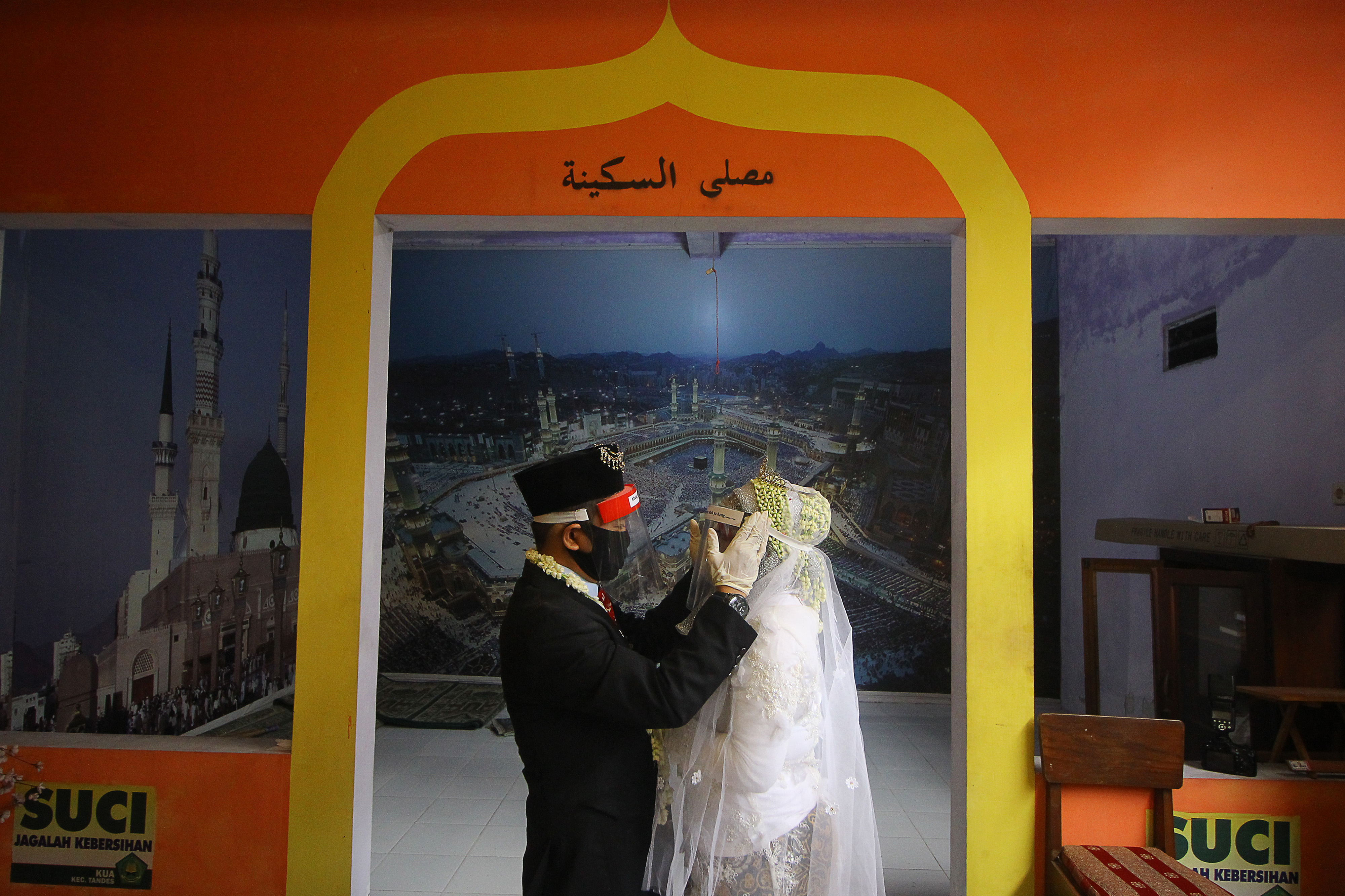 Pasangan pengantin seusai rangkaian akad nikah di Kantor Urusan Agama (KUA) Tandes, Surabaya, Jawa Timur, Kamis (21/5). 