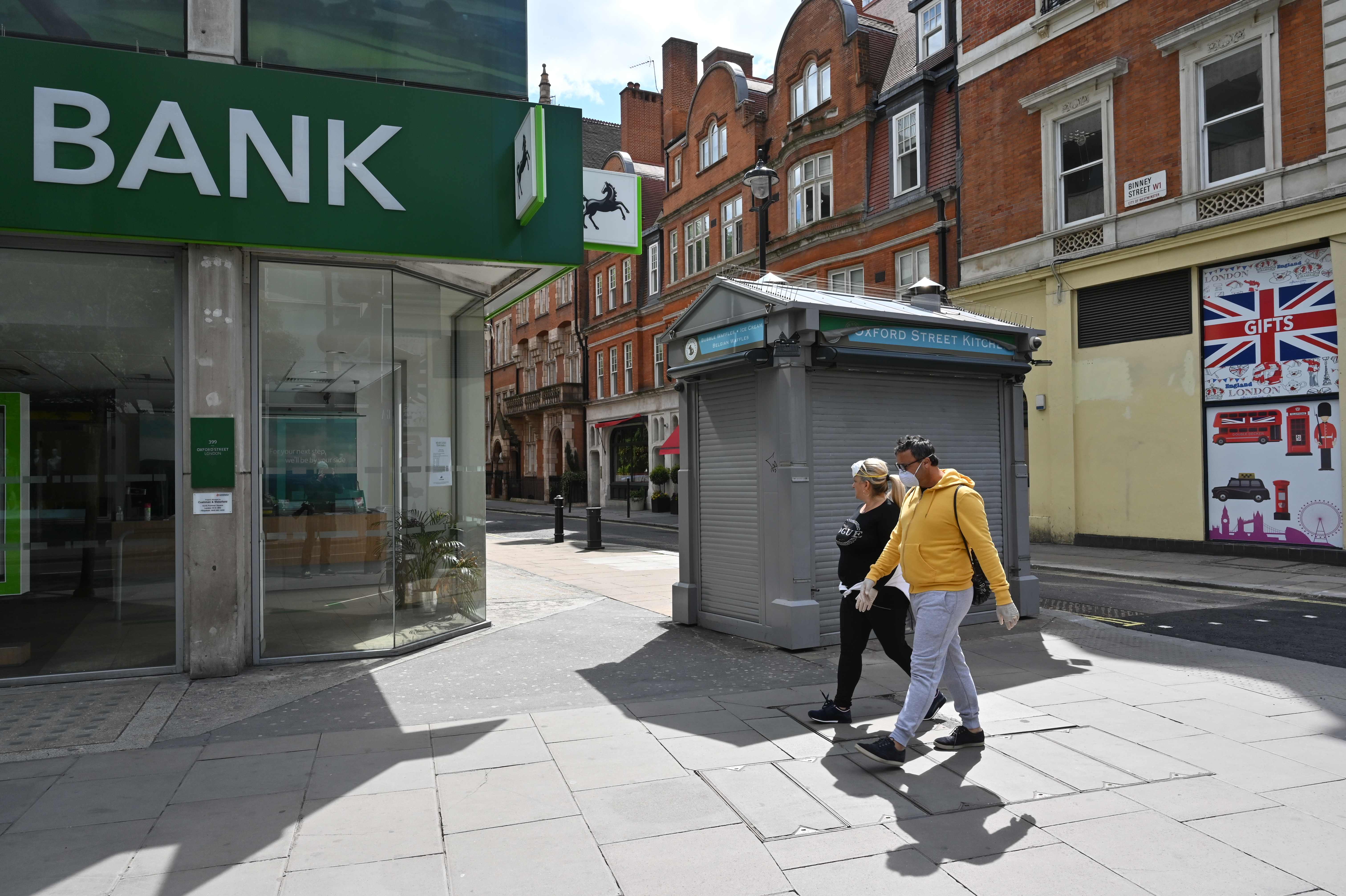 Pejalan kaki memakai masker melintasi Oxford Street, London. Hingga saat ini Inggris masih memberlakukan lockdown akibat pandemik covid-19.