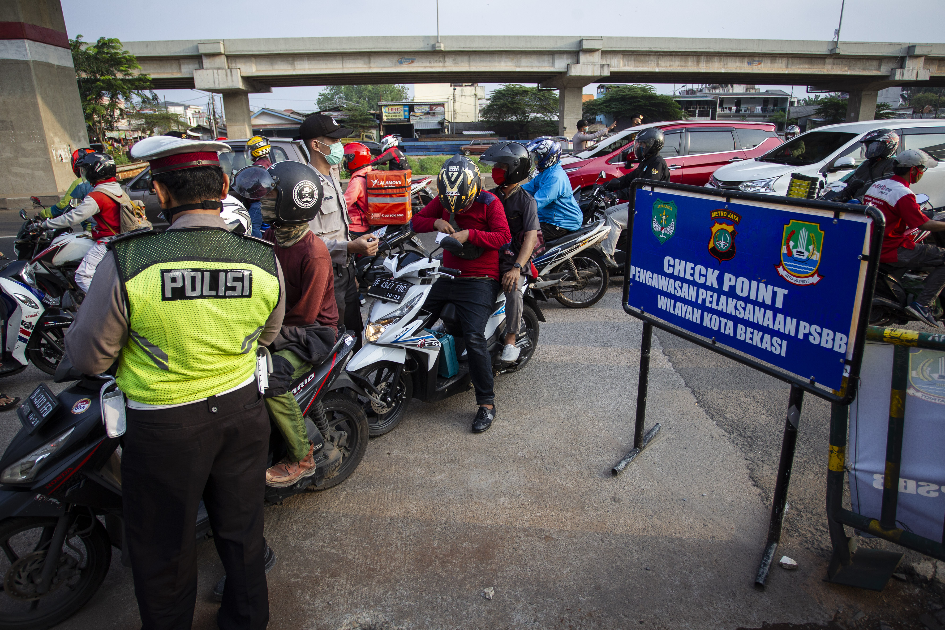 Petugas melakukan pengawasan terhadap kendaraan yang melintasi Check Point Pembatasan Sosial Berskala Besar (PSBB) di kawasan Kalimalang.