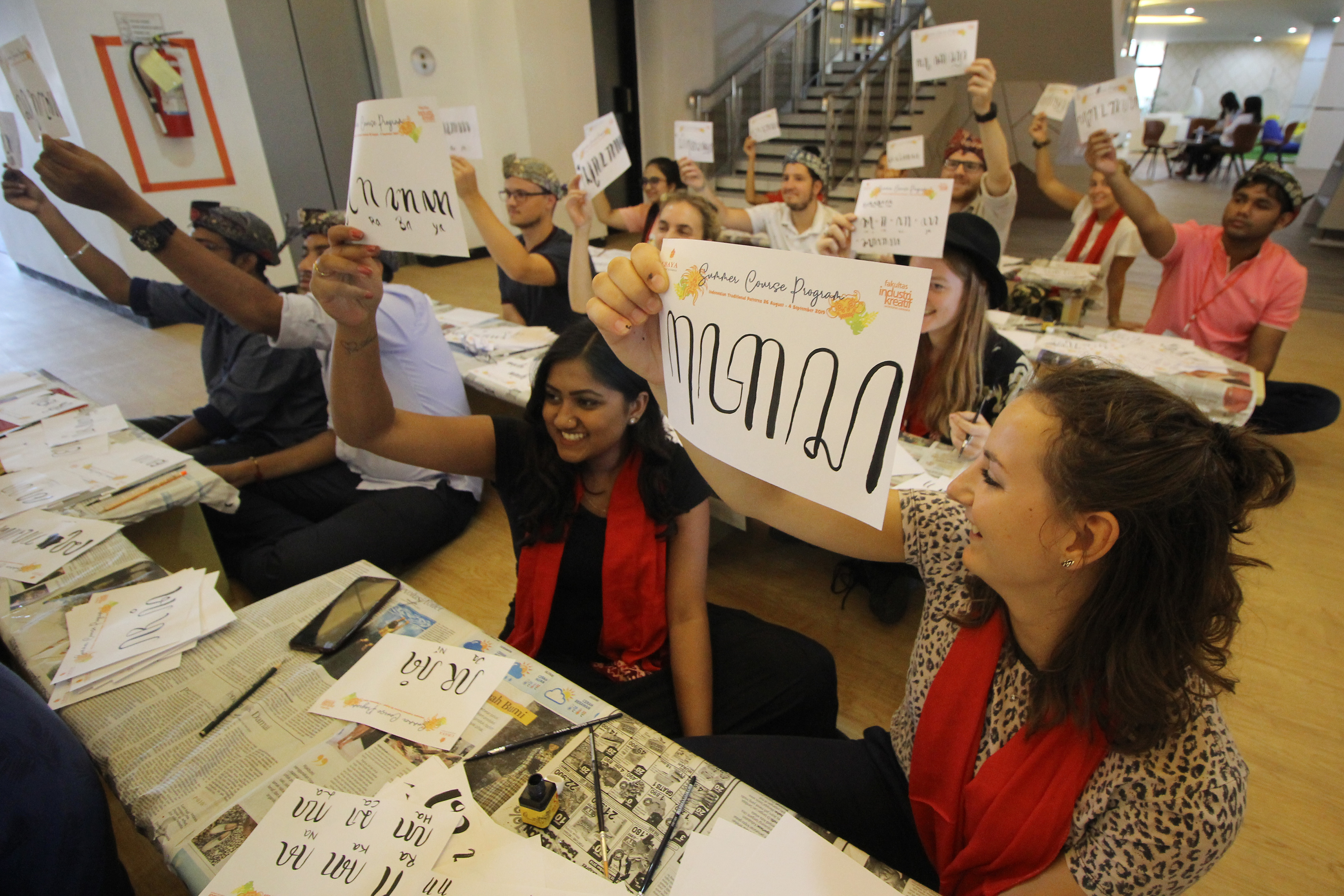 Sejumlah mahasiswa asing memperlihatkan tulisan aksara Jawa buatannya di Kampus Ubaya Surabaya