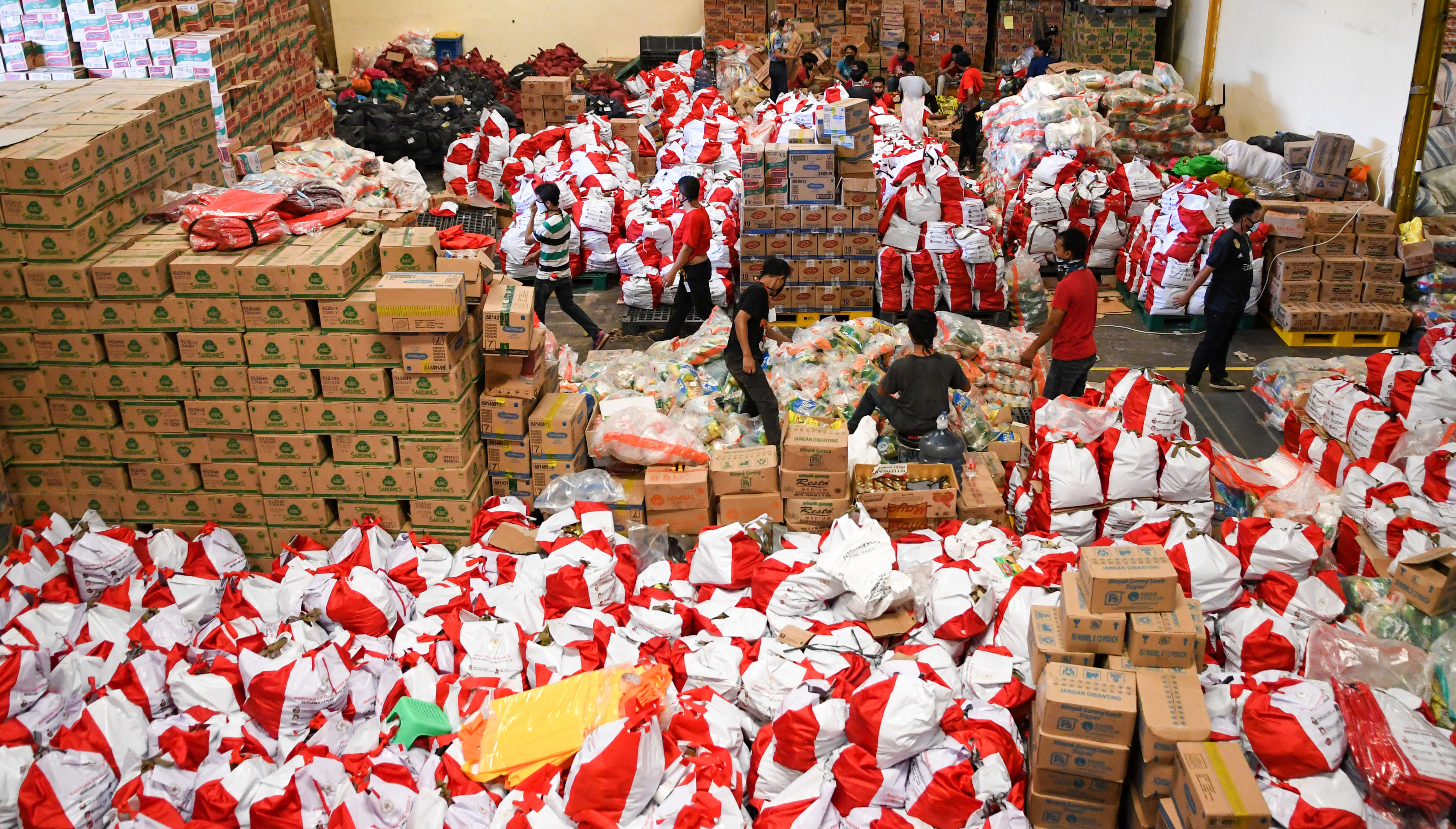 Pekerja mengemas paket bantuan sosial (bansos) di Gudang Food Station Cipinang, Jakarta, Rabu (22/4/2020). 
