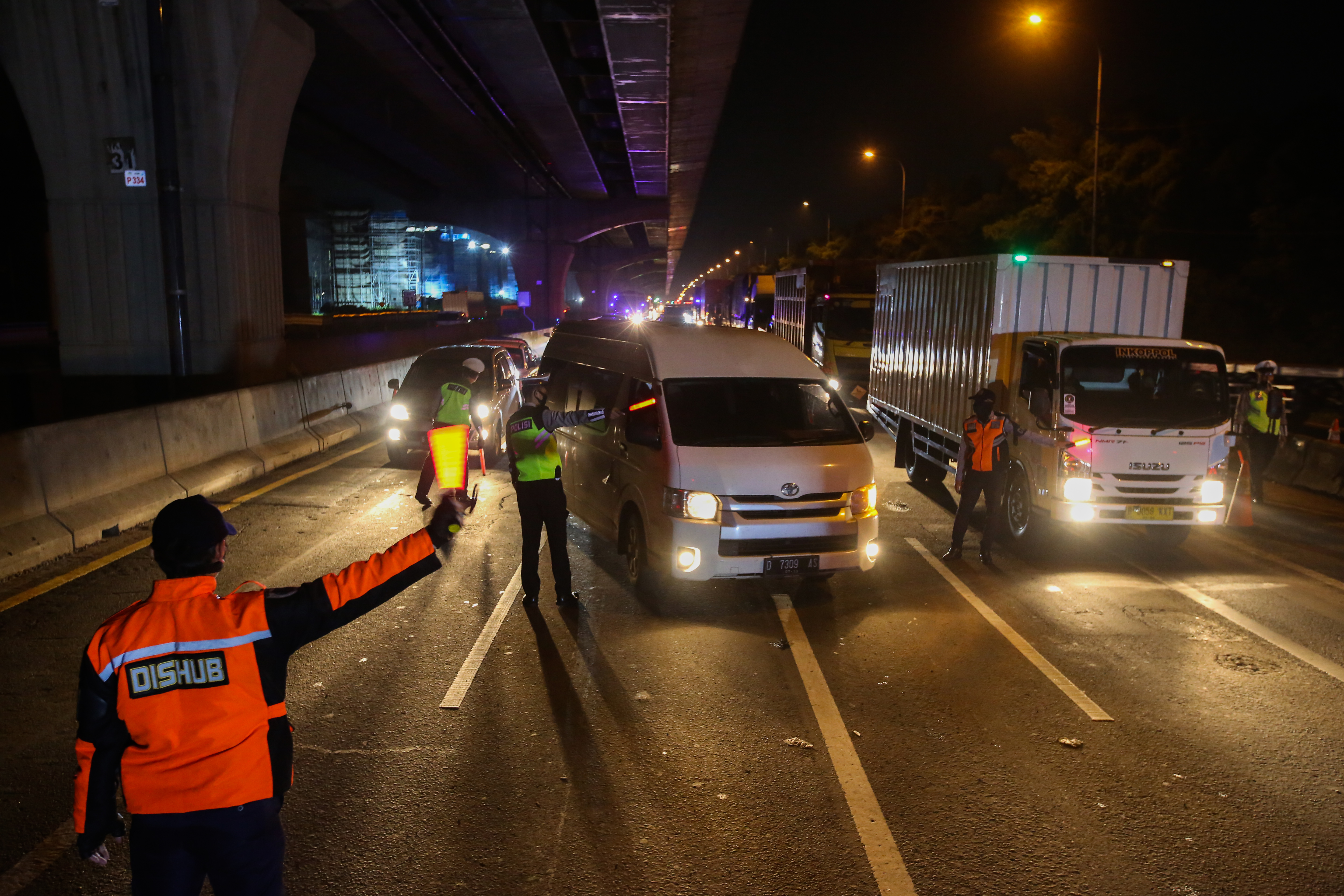 Petugas gabungan memeriksa kendaraan yang hendak meninggalkan Jakarta di Gerbang Tol Cikarang Barat.
