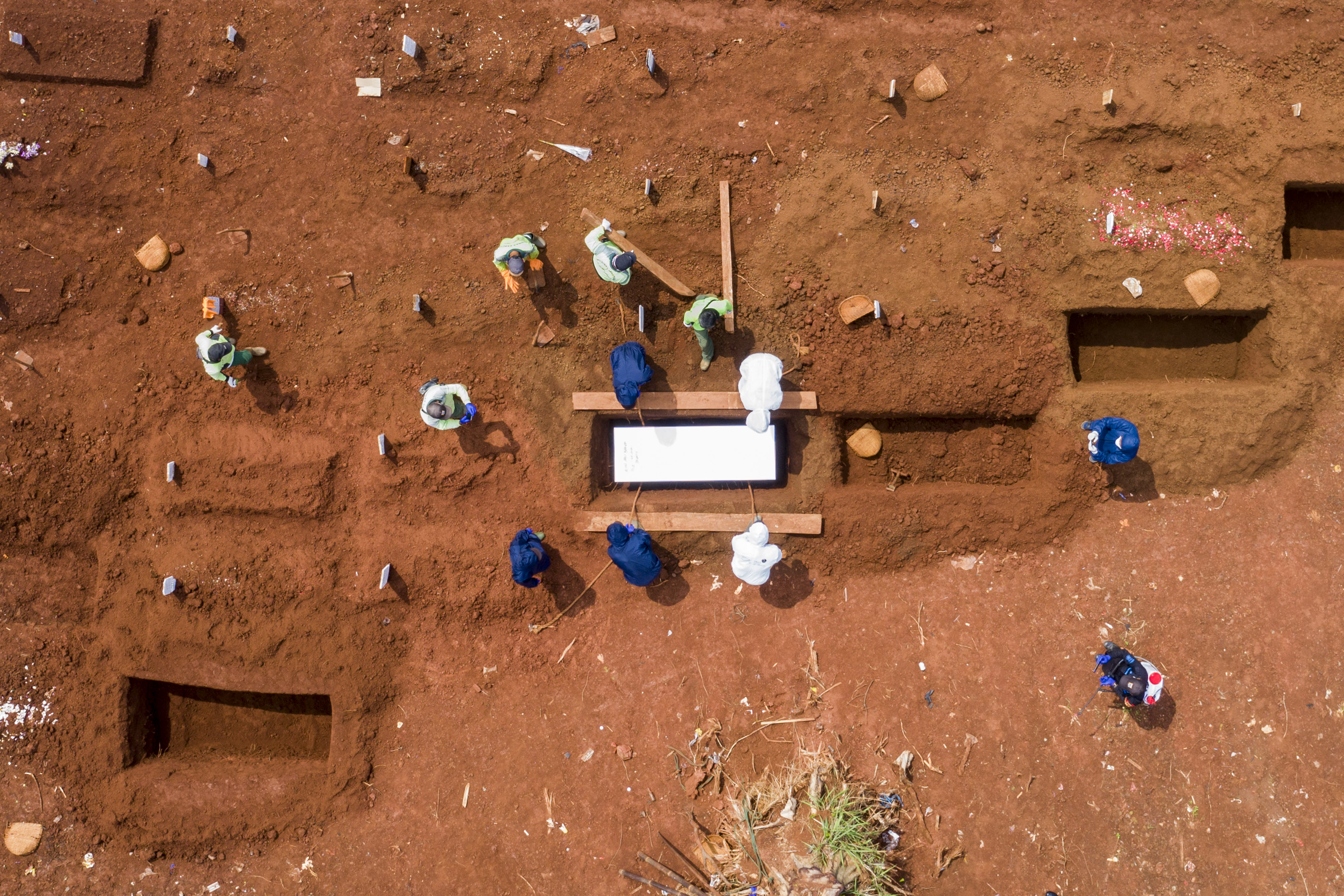 Petugas memakamkan jenazah kasus covid-19 di TPU Pondok Ranggon, Jakarta, Minggu (26/4).
