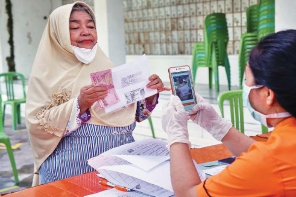 Warga penerima bantuan sosial tunai (BST) difoto petugas di Kantor Pos Palangkaraya, Kalimantan Tengah, kemarin.