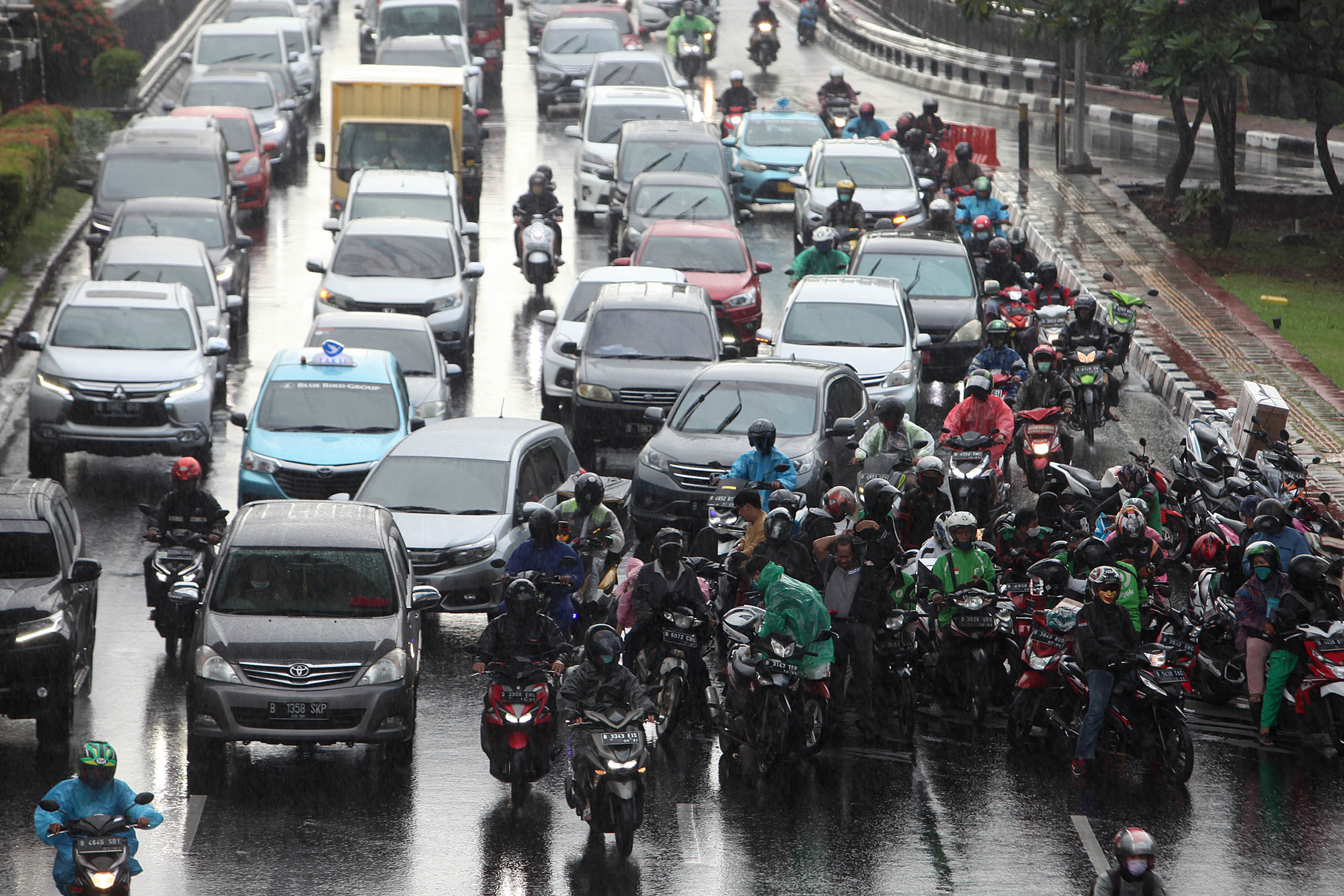 Pengendara berteduh di bawah jembatan kawasan Gatot Subroto saat hujan turun.