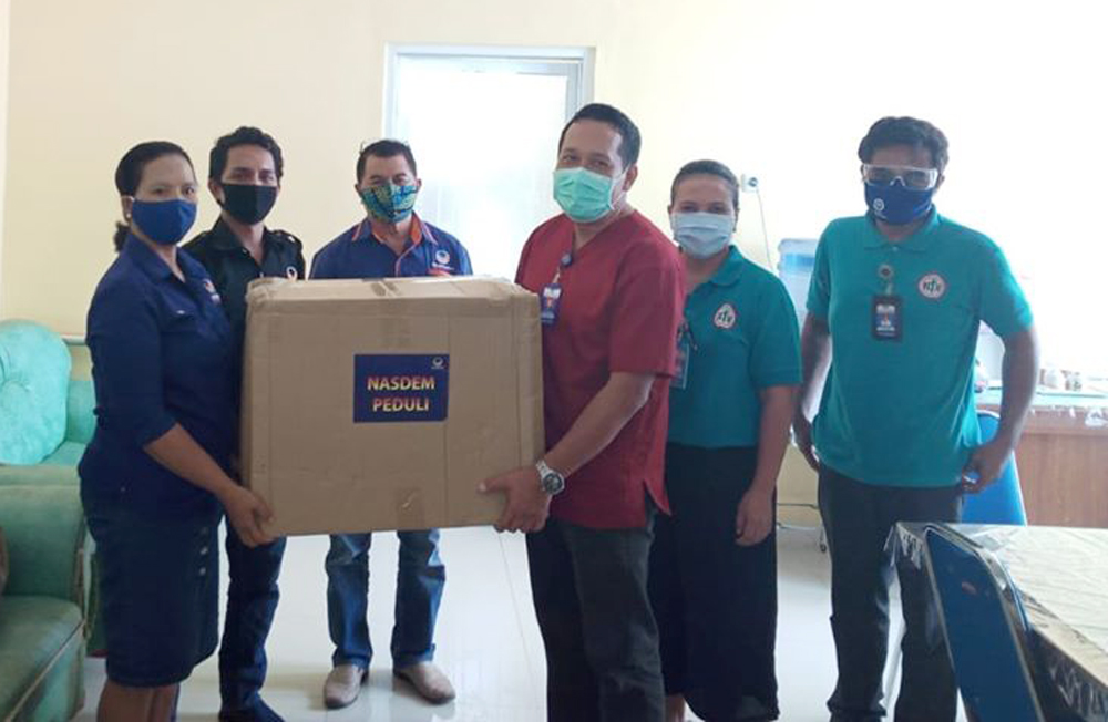Bendahara DPW Partai NasDem NTT Iswati Rihi Ha'u (kiri) menyerahkan bantuan 40 set APD kepada Wakil Ketua IDI NTT di Kupang, Rabu (6/5)