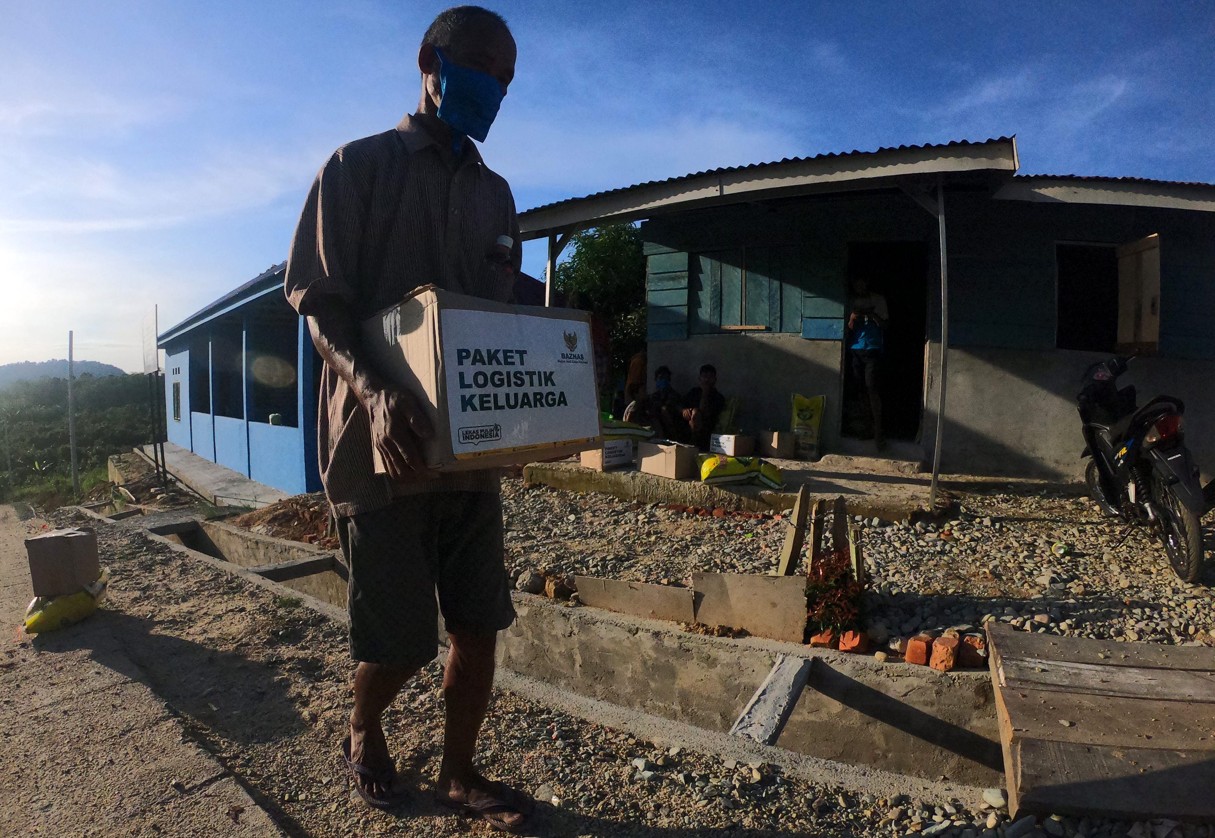 Warga membawa paket bantuan di Jambi, Selasa (19/5).