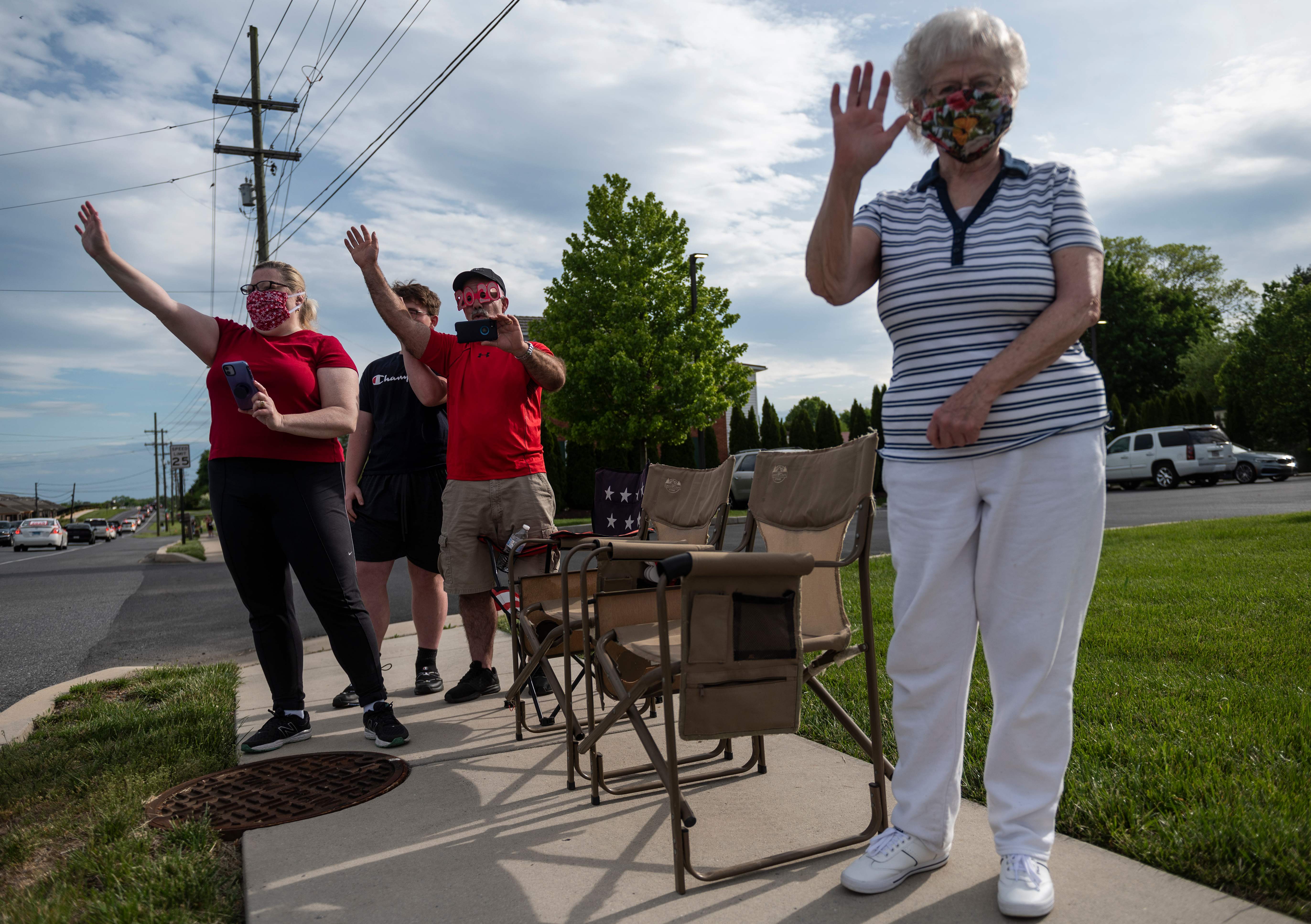 Warga Hagerstown, Maryland melambaikan tangan kepada rombongan siswa SMU yang merayakan kelulusan mereka dengan berkeliling kota.