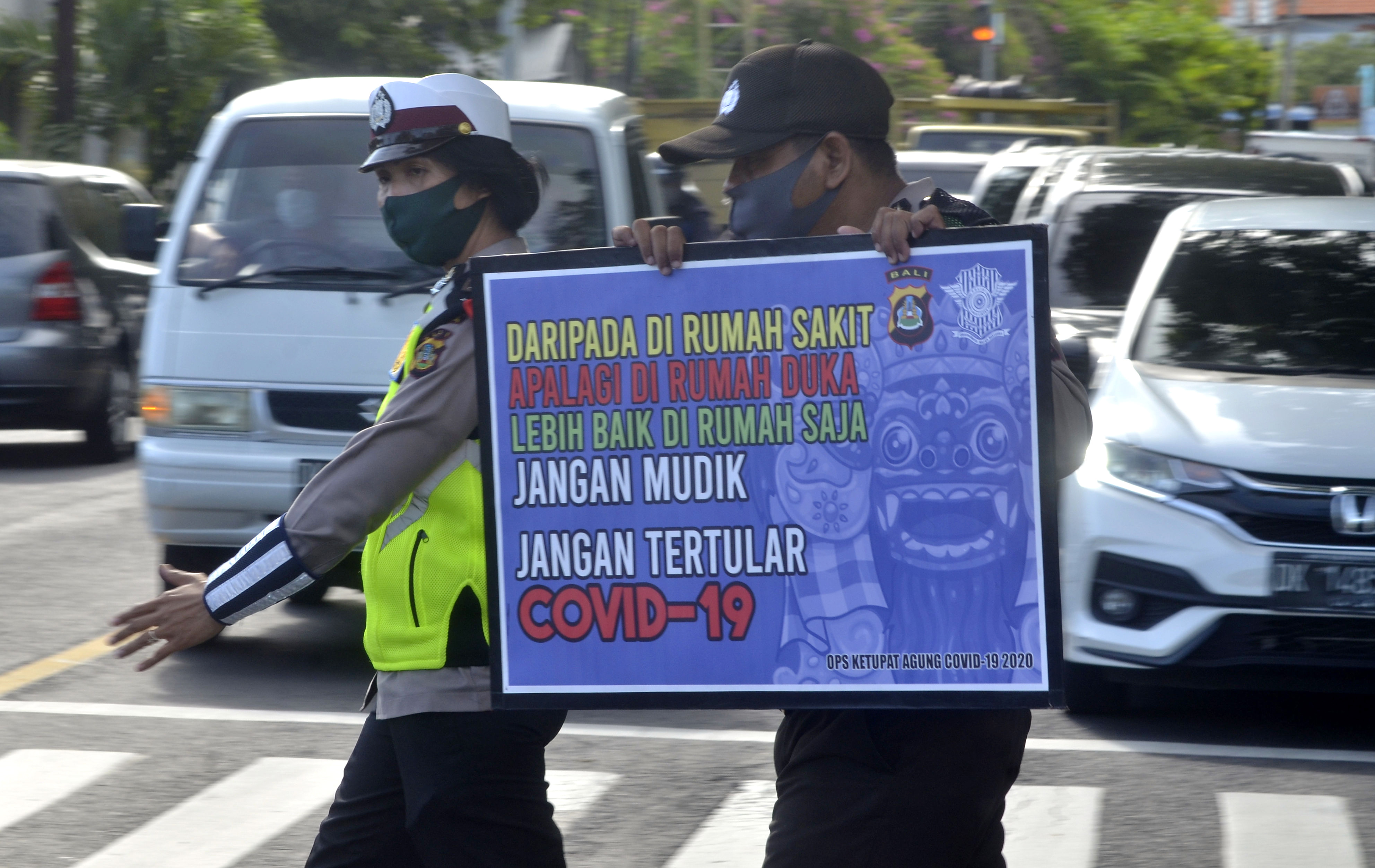 Petugas kepolisian melakukan kampanye pencegahan penularan virus korona di Denpasar, beberapa waktu lalu.