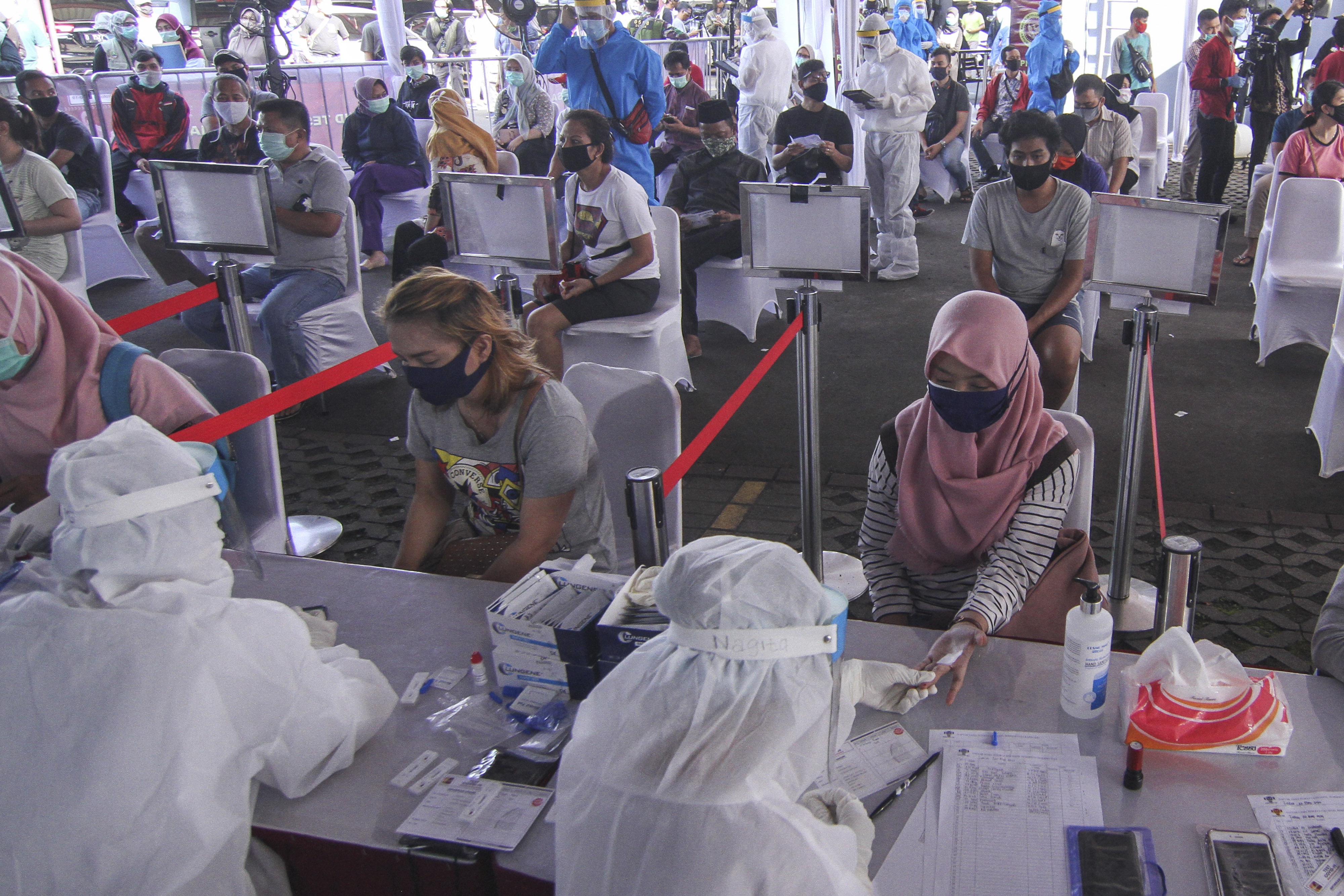 Petugas medis mengambil sampel darah warga saat rapid test massal di Depok, Jawa Barat, Jumat (22/5) yang digelar BIN.