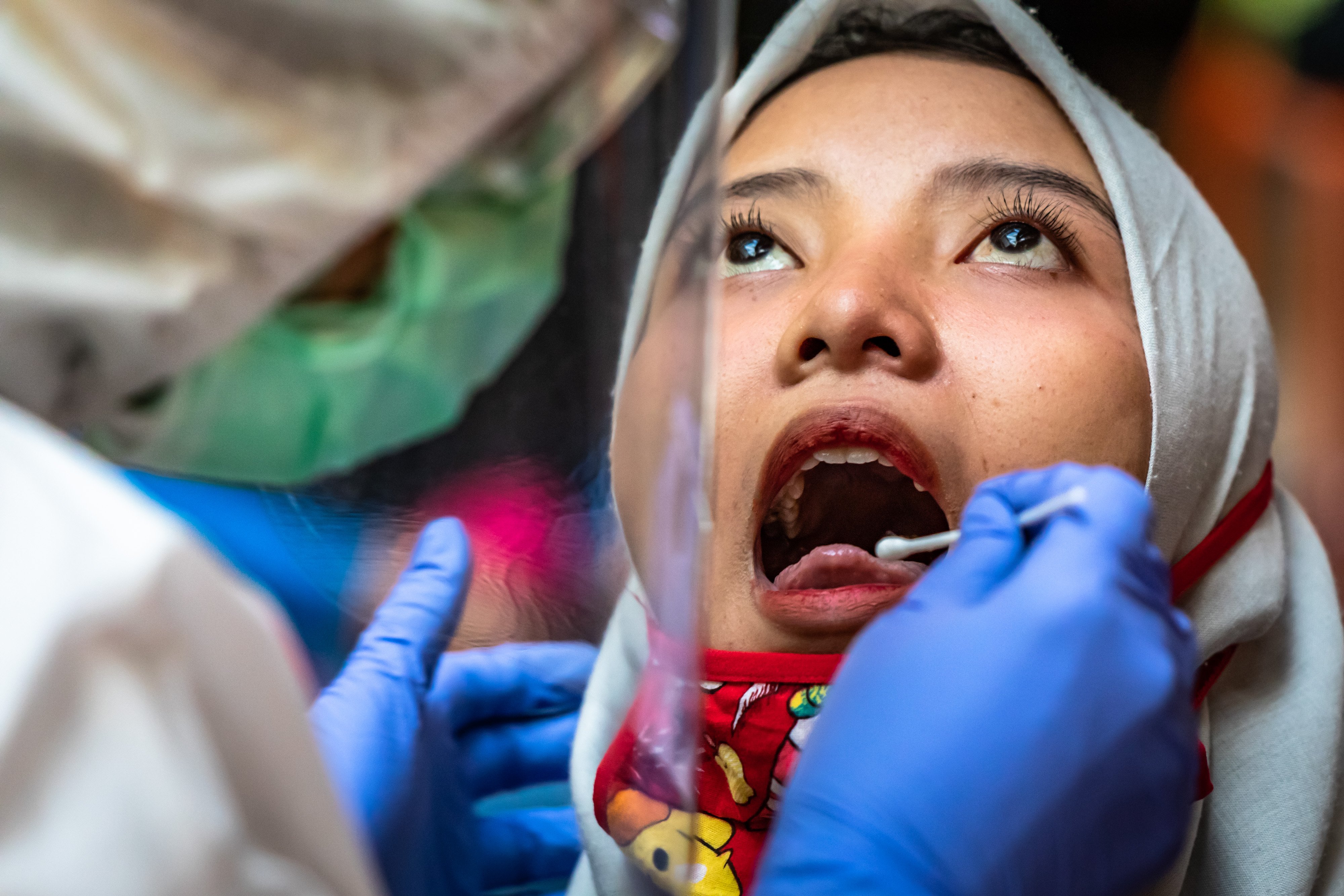 Ilustrasi--Petugas mengambil sampel lendir dari seorang warga saat tes swab covid-19.