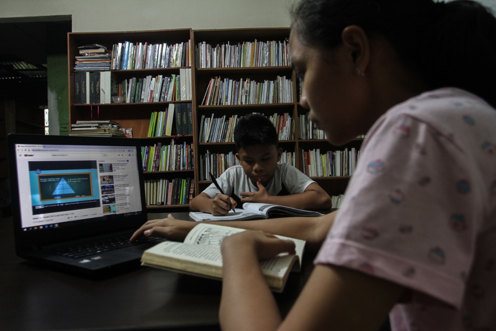  Siswa mengerjakan tugas sekolah di rumahnya