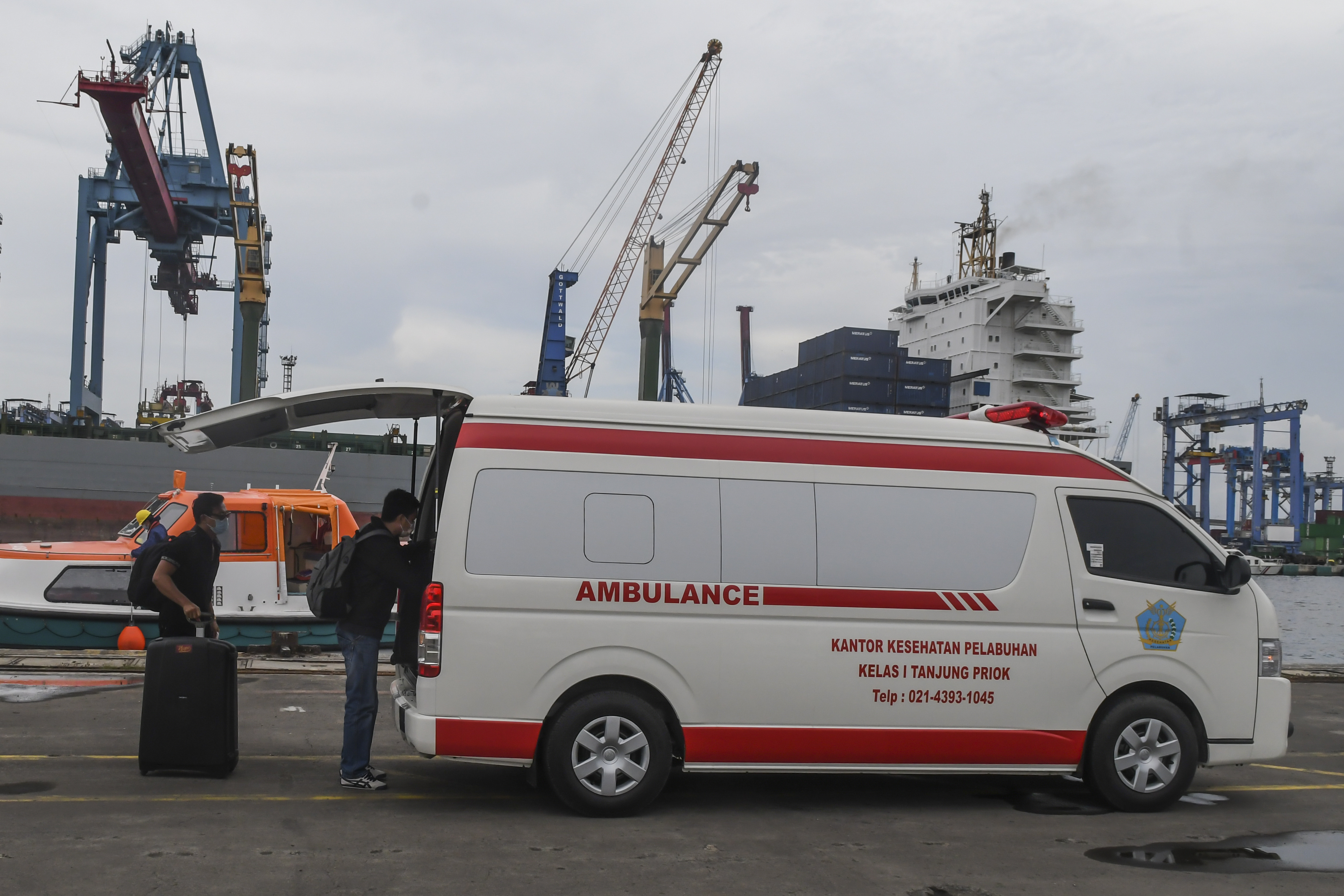 WNI anak buah kapal Kapal Pesiar MV Arthania yang diduga positif covid-19 memasukan barang miliknya ke ambulans di Pelabuhan Tanjung Priok.