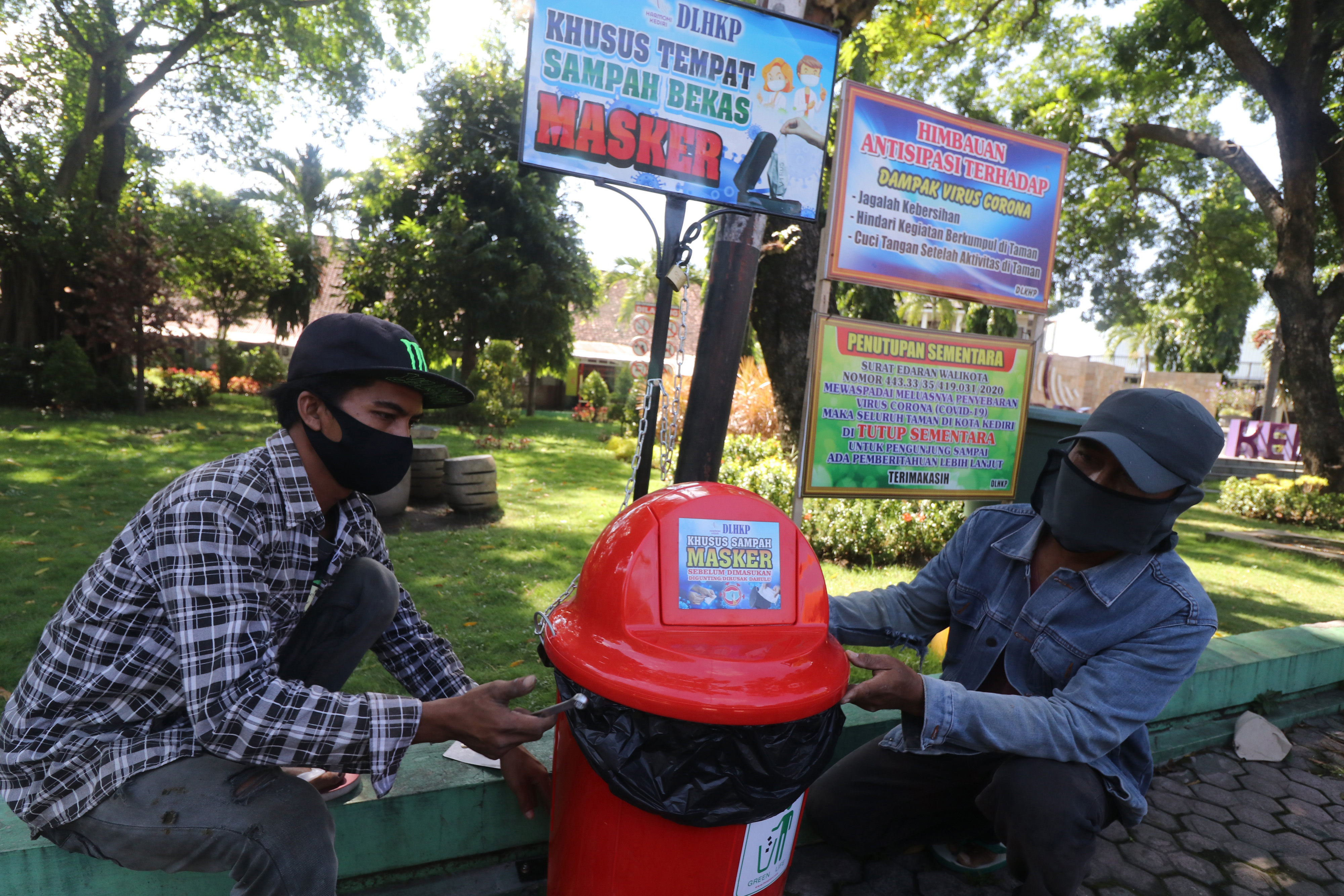 Pekerja memasang tempat sampah khusus untuk membuang masker bekas di pinggir jalan arteri di Kota Kediri, Jawa Timur, Selasa (12/5/2020).