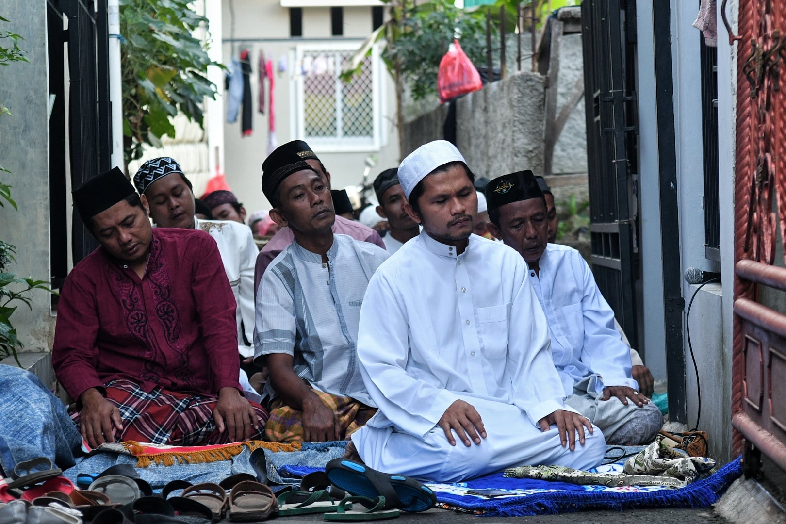 Warga menjalankan Salat Id berjamaah bersama keluarga dan kerabat dekat di depan rumahnya di Kawasan pekayon, Jakarta Timur, Minggu (24/5).