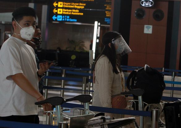 Calon penumpang pesawat menggunakan pelindung wajah dan sarung tangan di Terminal 3 Bandara Soekarno Hatta, Tangerang, Minggu (10/5/2020).