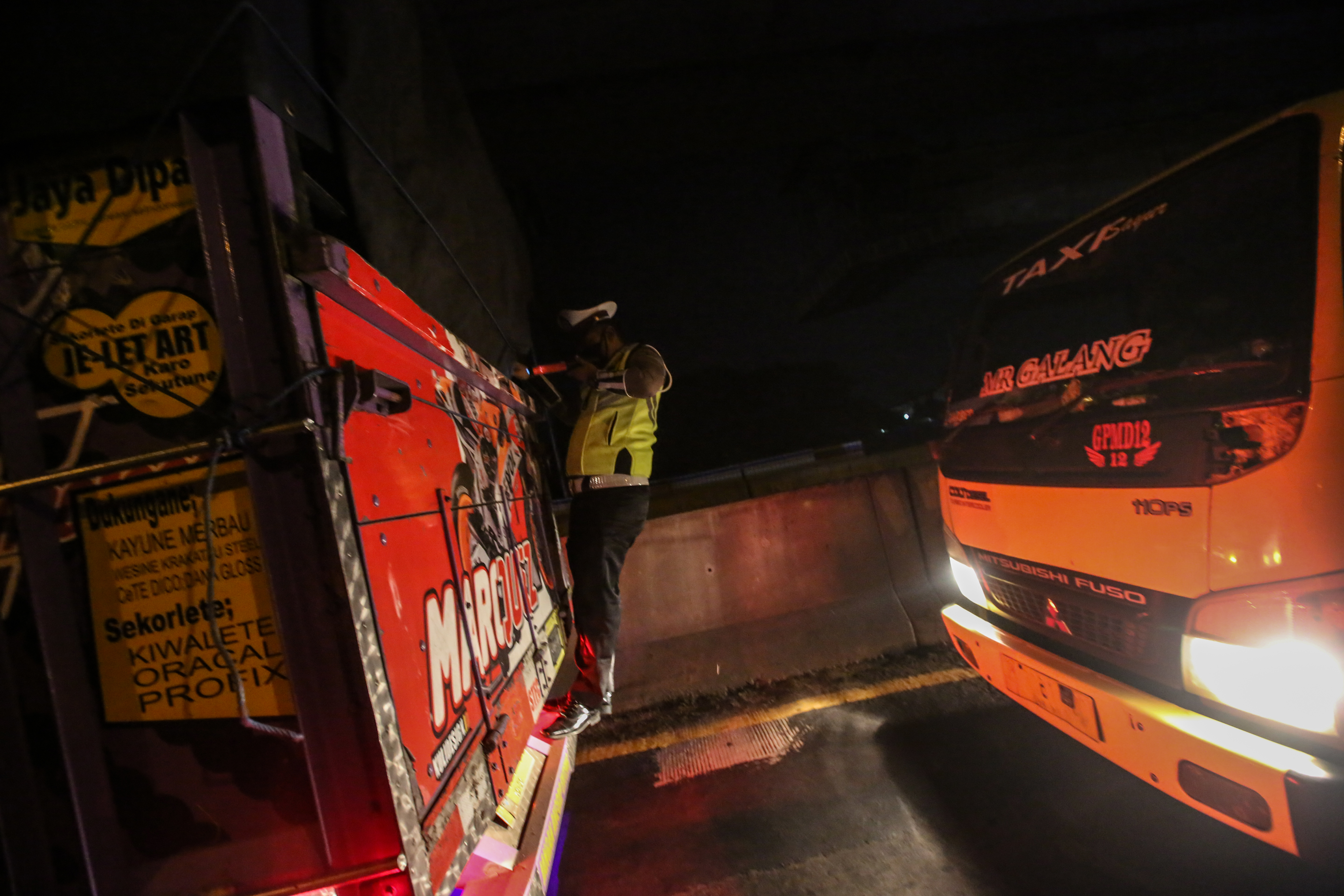 Polisi memeriksa muatan truk terkait lararang mudik di Gerbang Tol Cikarang Barat Bekasi (19/5/2020)