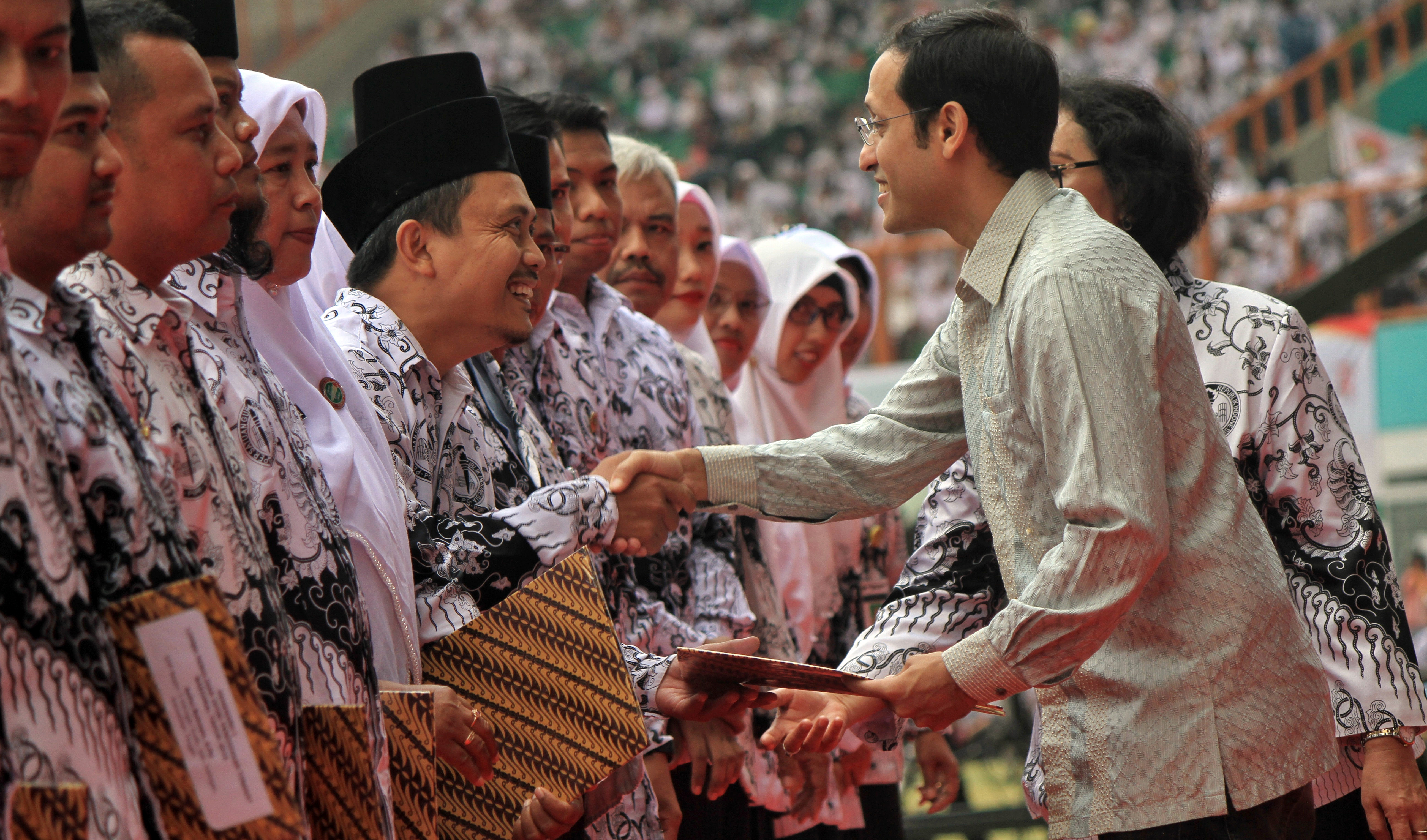 Menteri Pendidikan dan Kebudayaan Nadiem Makarim (kanan) menyerahkan penghargaan guru inspiratif