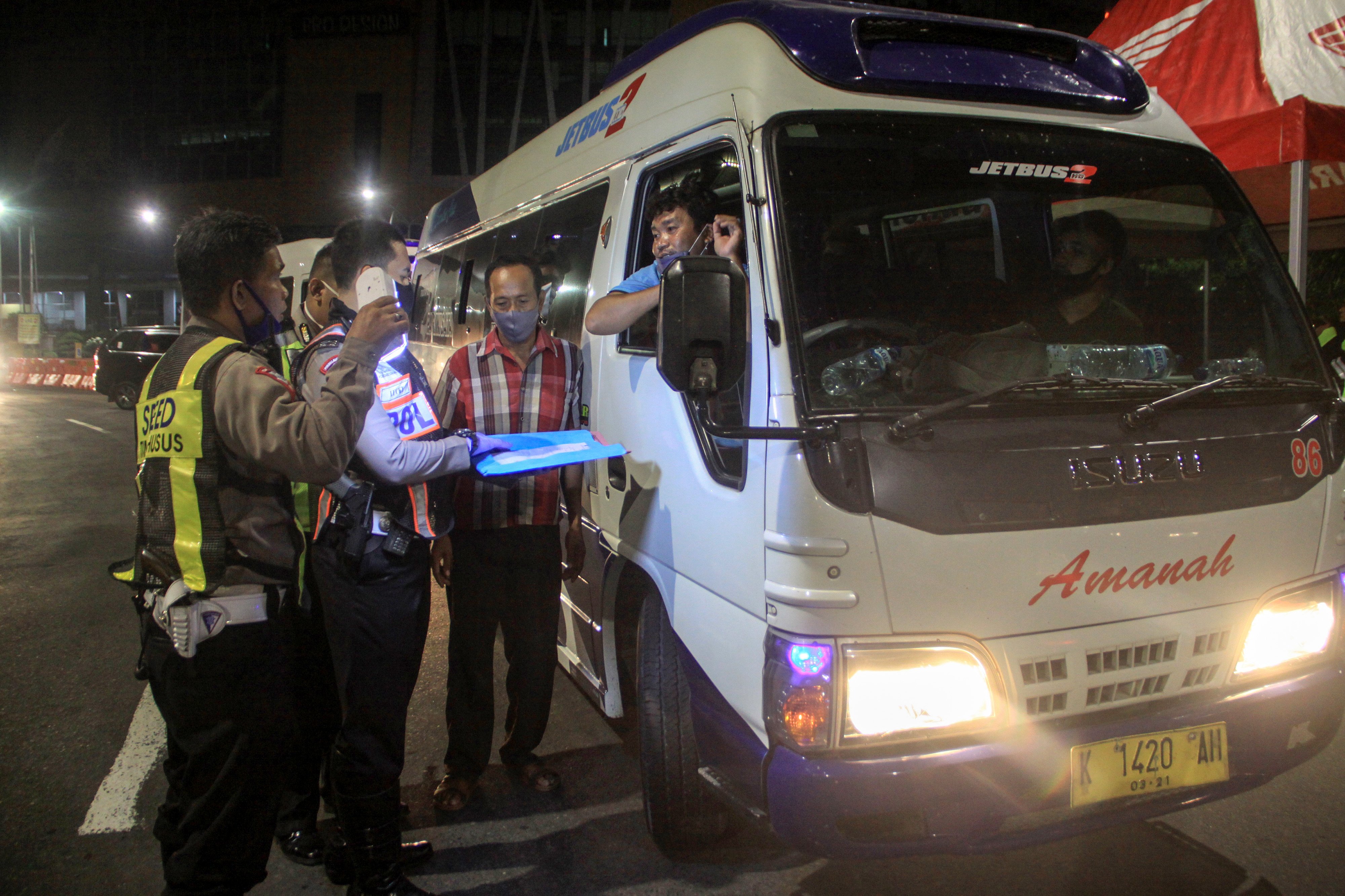Petugas memeriksa dokumen kendaraan yang akan masuk ke Surabaya di Bundaran Waru, Surabaya, Jawa Timur, Selasa (12/5/2020) malam.