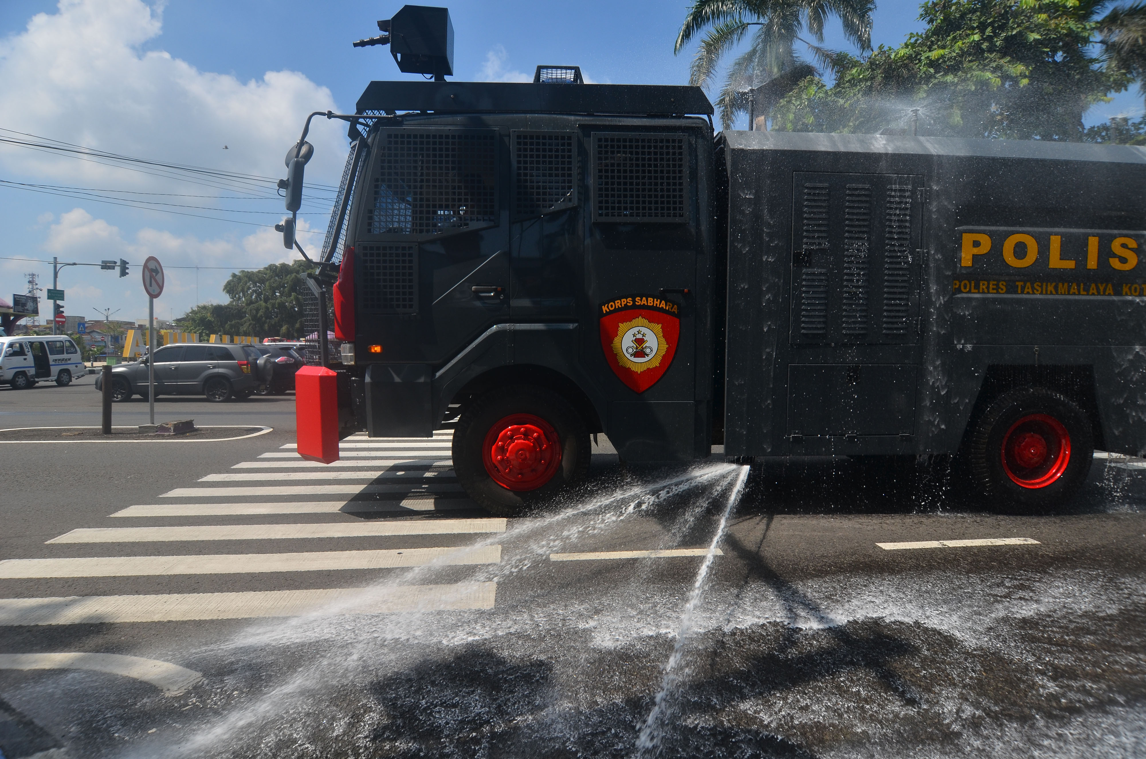 Polisi menyemprotkan disinfektan menggunakan mobil armor water canondi Jalan Ahmad Yani, Kabupaten Ciamis, Jawa Barat.