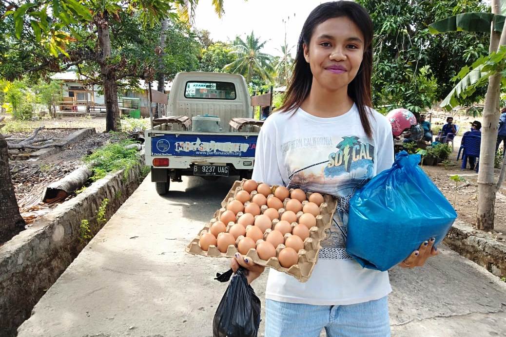 Seorang warga Desa Hadakewa, Kecamatan Lebatukan, semringah menerima paket bantuan dari anggota DPR RI Fraksi Nasdem, Juli Laiskodat.