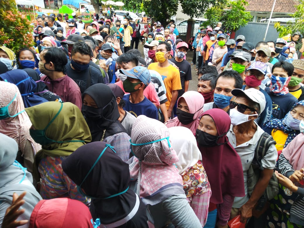 Warga Kelurahan Karsamenak, Kecamatan Kawalu, Kota Tasikmalayan mengabaikan protokol kesehatan saat akan mengambil bantuan sosial tunai.