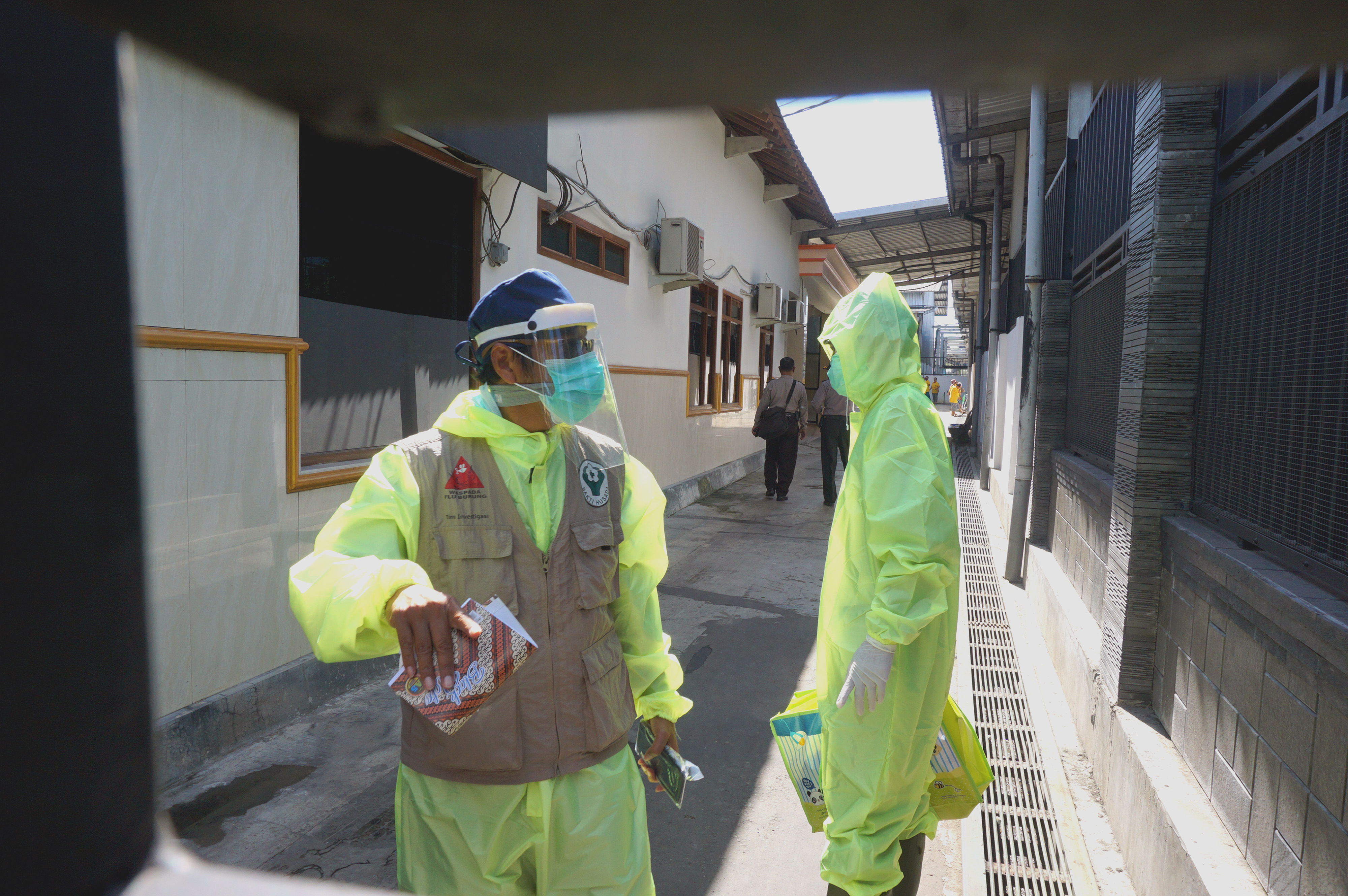 Petugas kesehatan berjalan memasuki gudang produksi pabrik rokok Mustika dan Trubus di Desa Gesikan, Tulungagung, Jawa Timur, Sabtu (2/5).