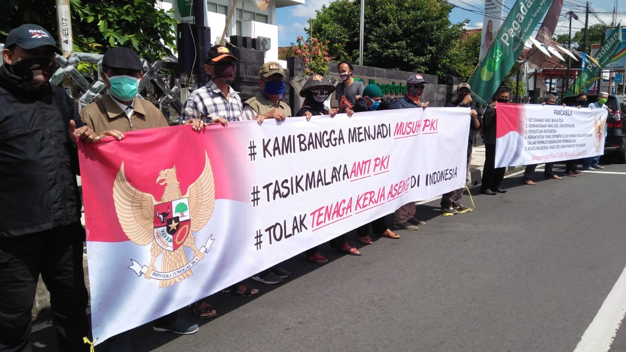 Sejumlah warga membentangkan spanduk menolak keberadaan Partai Komunis Indonesia (PKI) di Indonesia saat peringatan hari lahir pancasila.