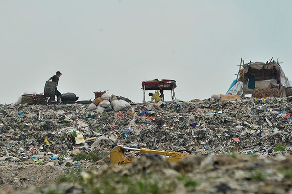 Pekerja mengangkut sampah di kawasan Tempat Pembuangan Akhir (TPA)