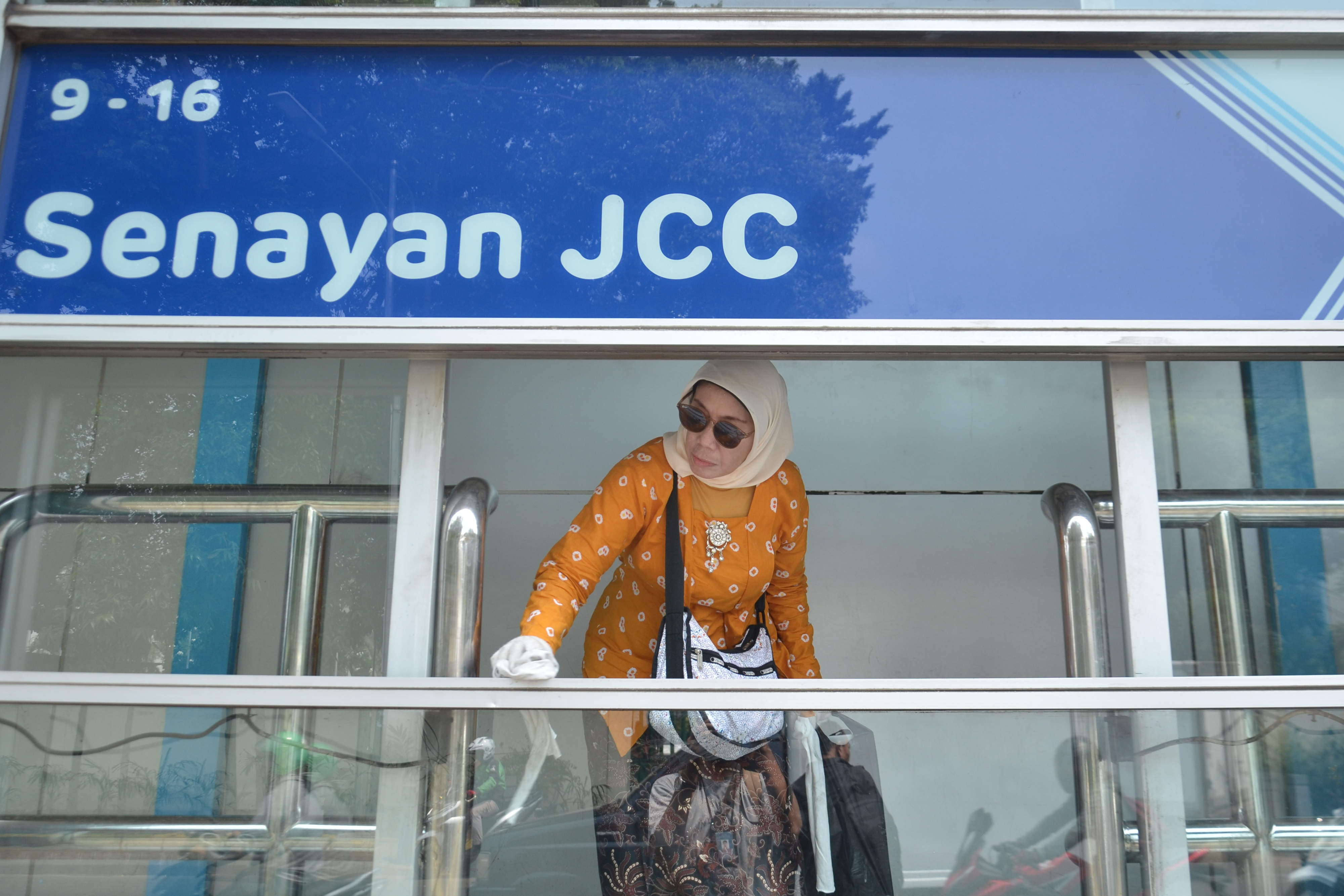 Warga sedang mengecat halte transjakarta Senayan JCC, Jakarta, Sabtu (26/10/2019). 