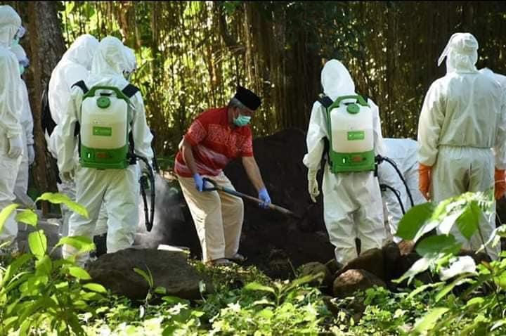 Wali Kota Tidore Kepulauan, Ali Ibrahim menaburkan tanah di atas makam istrinya Salama yang meninggal akibat covid-19, Senin (1/6/2020).