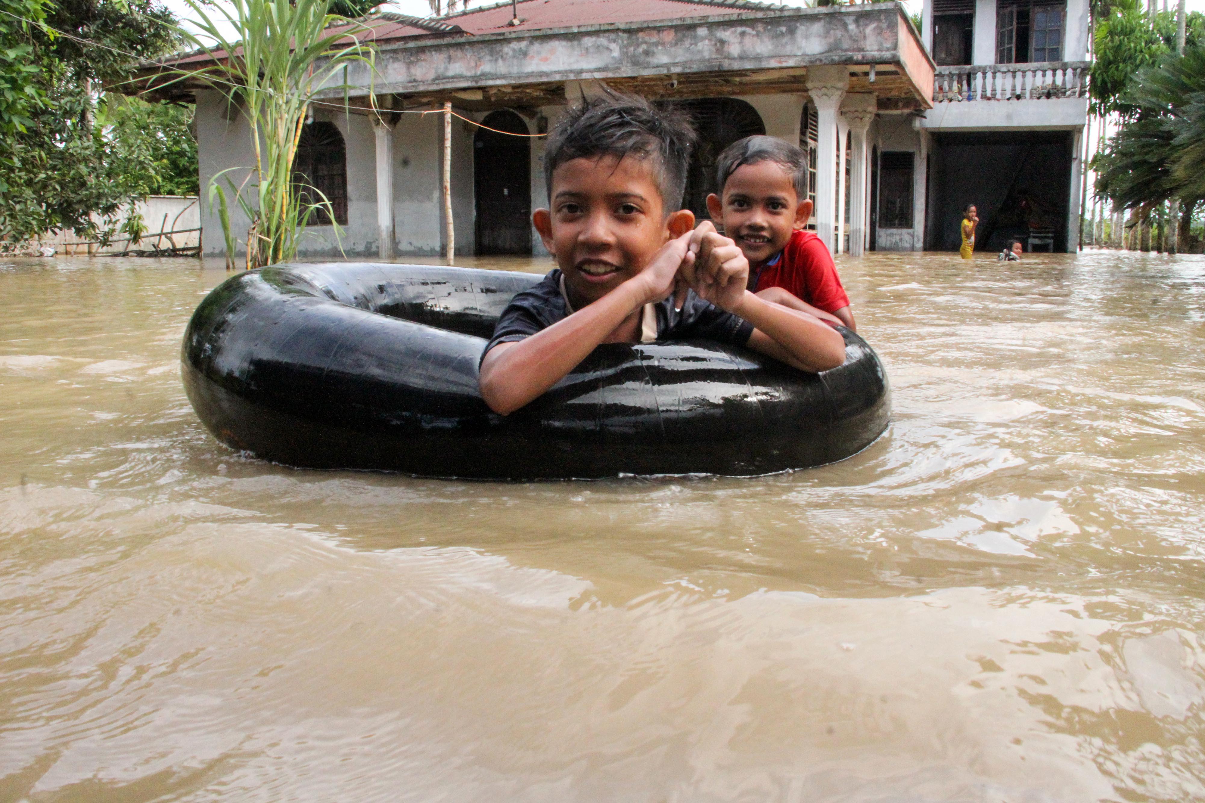 Sejumlah anak bermain dengan banjir yang merendam Desa Alue Thoe, Matangkuli, Aceh Utara (18/5/2020)