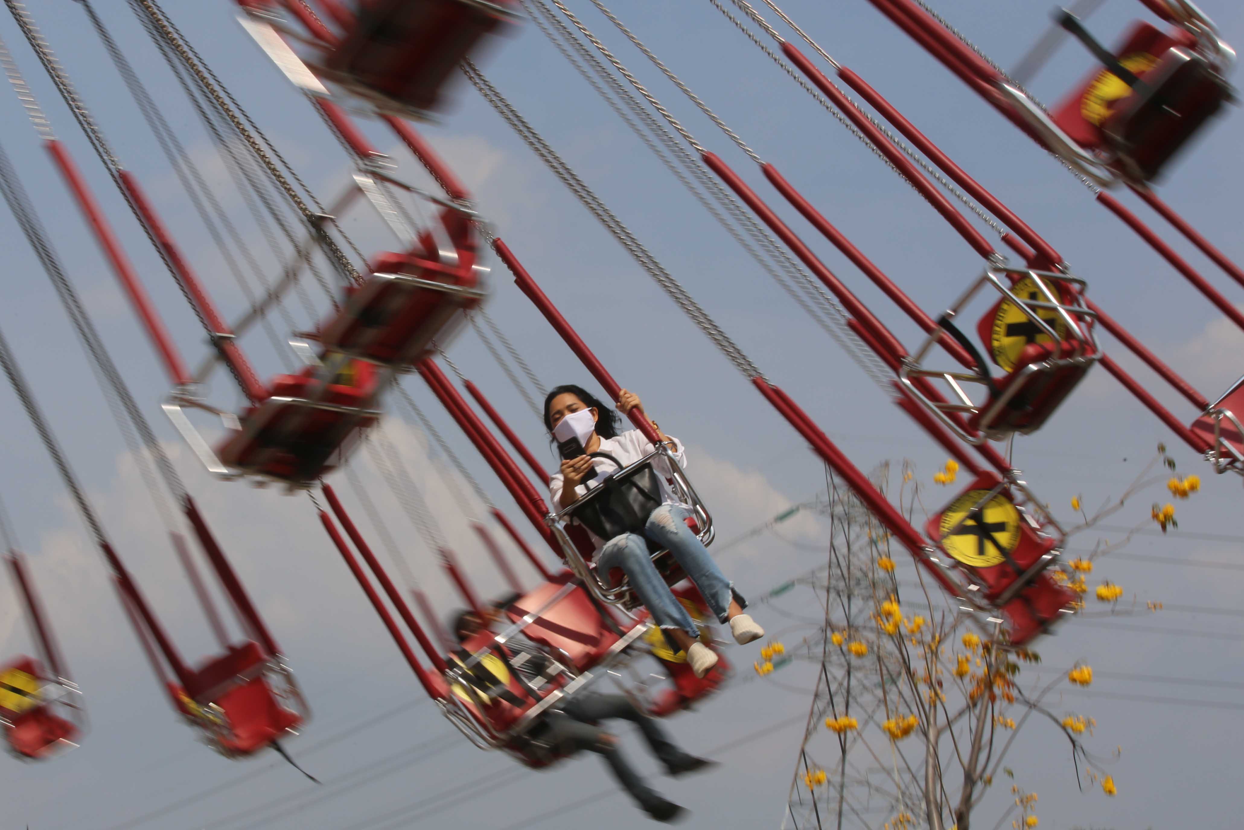 Pengunjung menikmati wahana permainan di Dunia Fantasi, Ancol, dengan menerapkan protokol kesehatan.