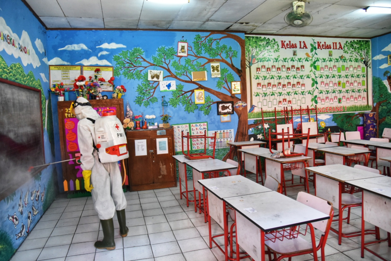 Petugas menyemprot cairan disinfektan di SDN 01 Kota Tangerang, Banten.