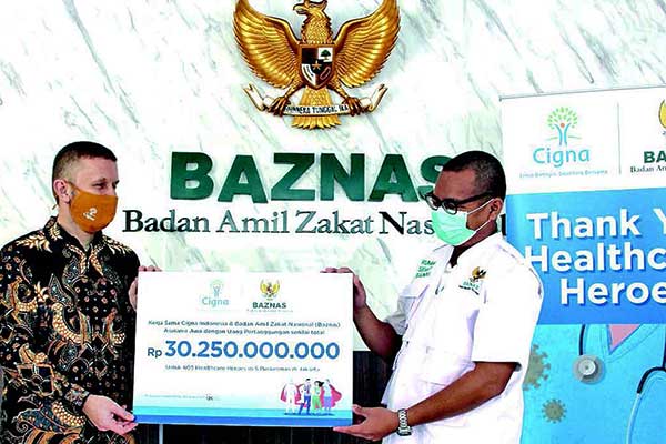 Presdir Cigna Indonesia Phil Reynolds (kiri) menyerahkan bantuan asuransi jiwa kepada Direktur Rumah Sehat Baznas Reza Ramdhoni di Jakarta.