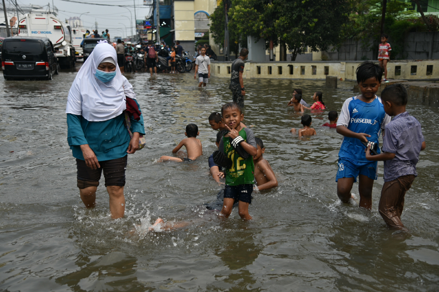 Warga melintasi banjir air rob di kawasan Muara Baru, Penjaringan, Jakarta Utara, Jumat (5/6). 