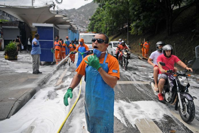  Ilustrasi: Petugas sibuk menyemprotkan cairan disinfektan di jalan untuk melawan penyebaran Covid-19.  