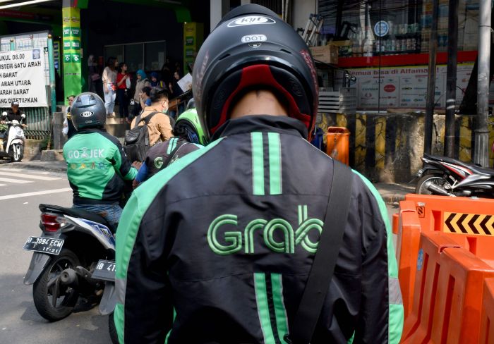 Seorang pengemudi Grab sedang menunggu calon penumpang.  