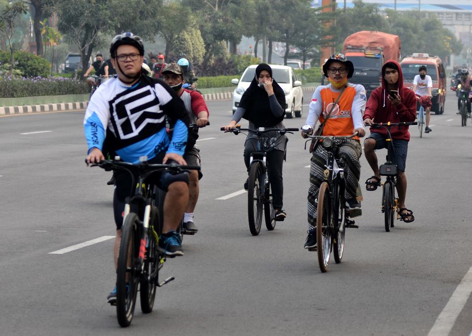 Sejumlah warga mengisi hari libur dengan olahraga bersepeda di Jalan Ahmad Yani, Bekasi, Jawa Barat, Minggu (28/6/2020).