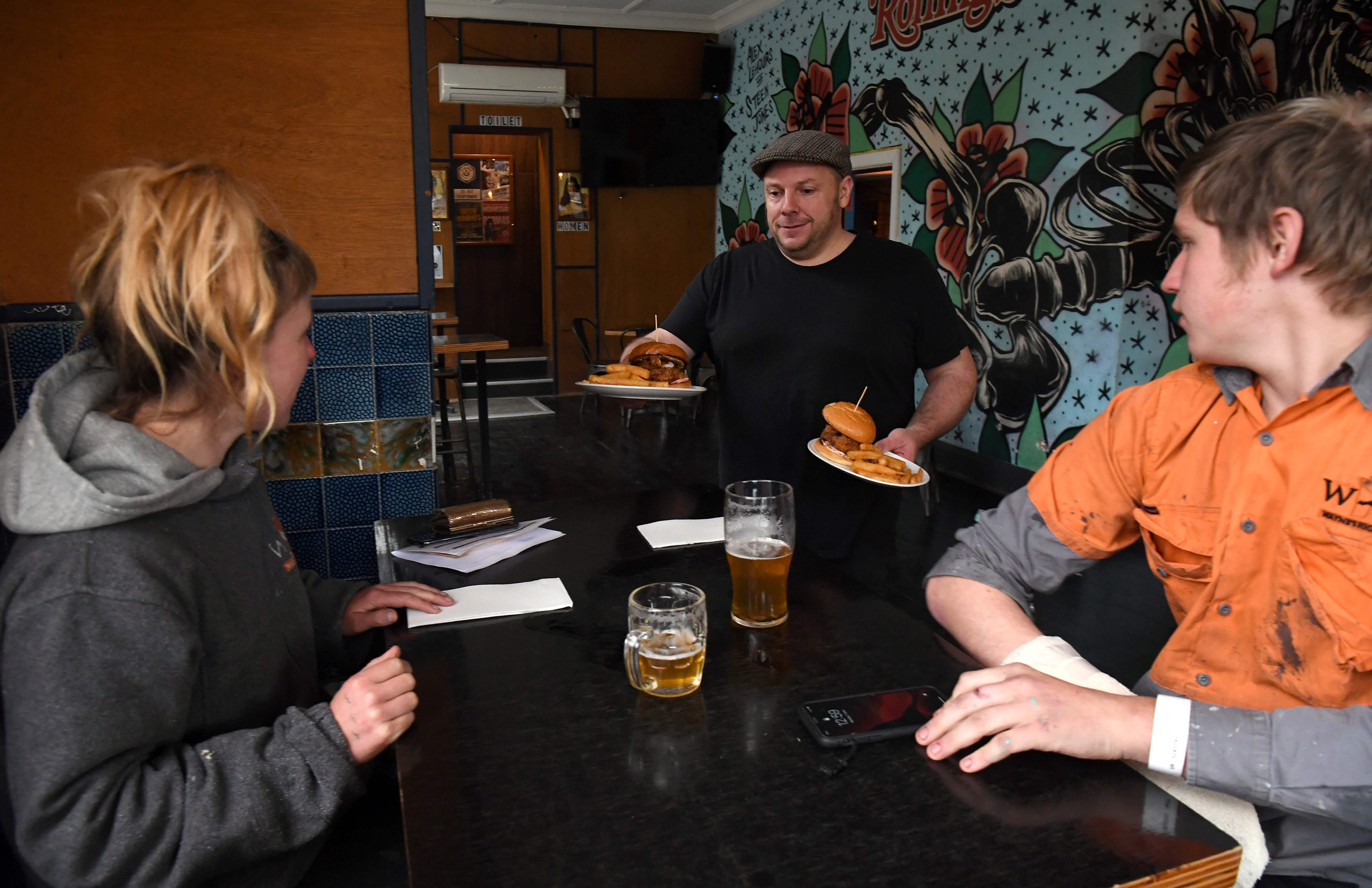 Venue manager Nat Presutto melayani pelanggan di the Workers Club pub, Melbourne pada  1 Juni 2020