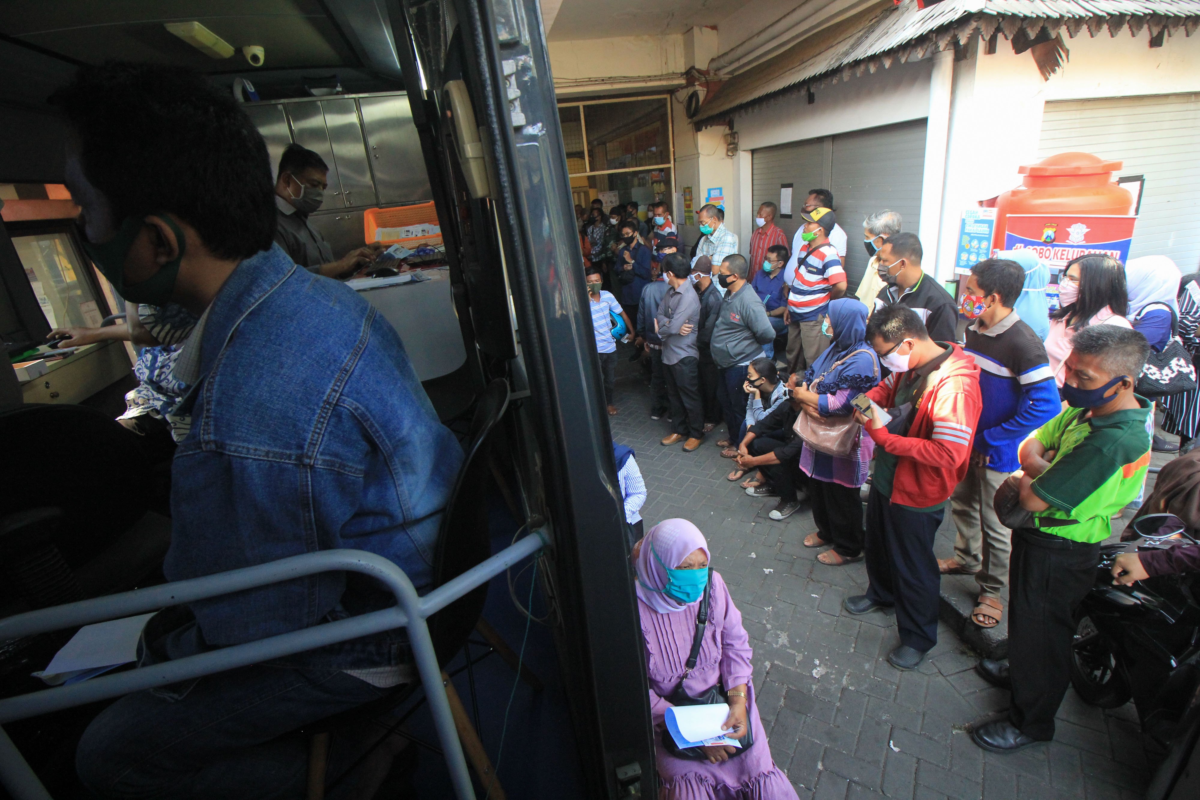 Ratusan orang antre mengurus perpanjangan Surat Ijin Mengemudi (SIM) di layanan SIM keliling di Pasar Tambak Rejo, Surabaya