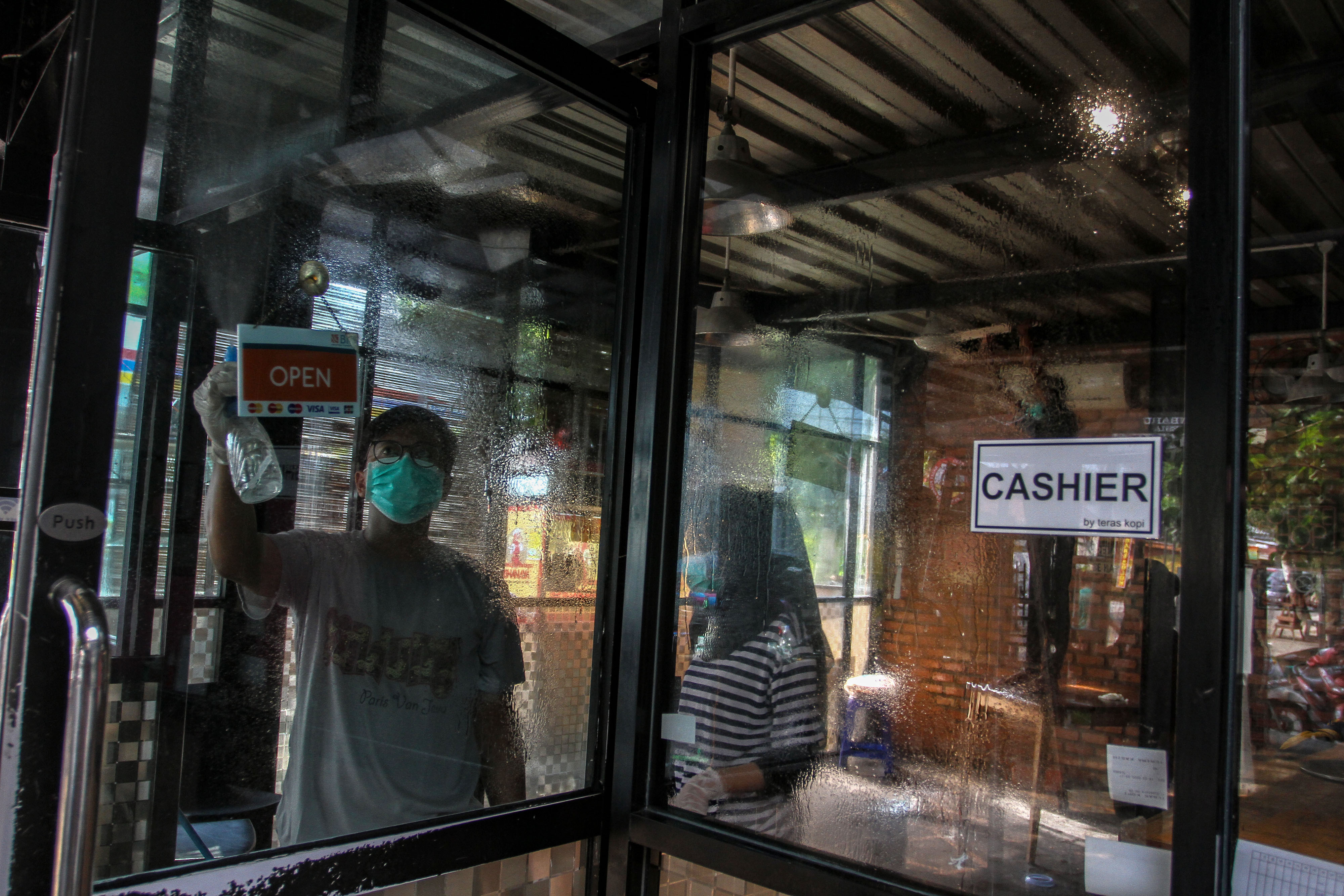 Sejumlah pekerja di salah satu cafe penjualan kopi menyemprotkan cairan disinfektan di saat melakukan pembersihan di Pekanbaru, Riau