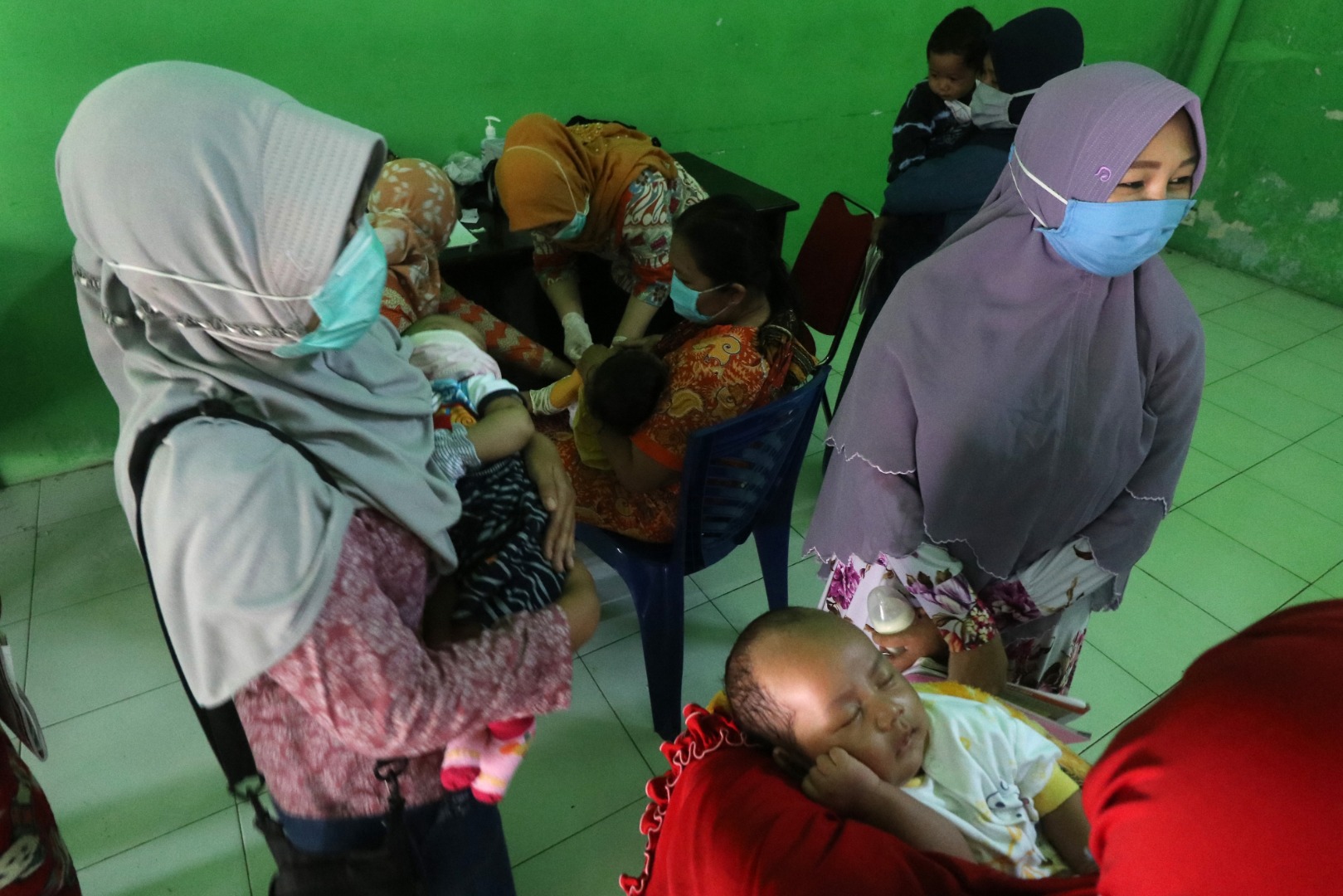 Sejumlah ibu bersama bayinya antre untuk mendapatkan imunisasi di kantor Kelurahan Pesantren, Kota Kediri, Jatim, Kamis (14/5/2020)