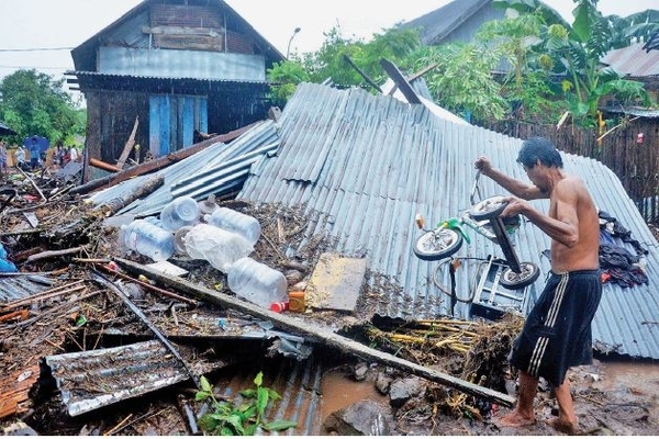 Warga mengangkat sisa barangnya akibat arus banjir bandang di Kecamatan Bissappu, Kabupaten Bantaeng, Sulawesi Selatan, kemarin.