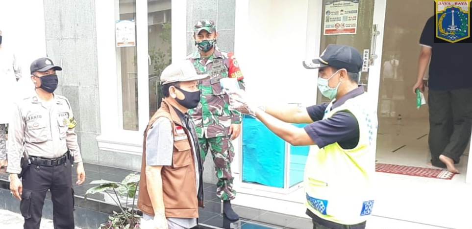 Lurah Kemanggisan  Firmansyah, SE diperiksa suhu tubuhnya sebelum masuk Musala Al-Garuda kawasan Merdeka Covid-19 di Kemanggisan.