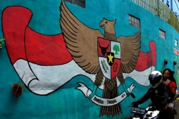 Ilustrasi -- Pengendara melintas di depan mural Garuda Pancasila yang ada di perkampungan warga di Ciputat, Tangerang Selatan, (28/11)