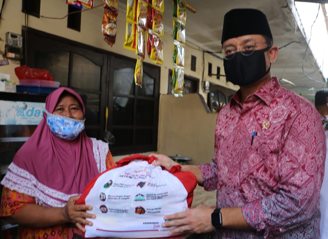 Mensos Juliari P. Batubara (kanan) memberikan paket bansos sembako Presiden di RW 03 Pondok Kelapa, Kecamatan Duren Sawit, Jakarta Timur.   